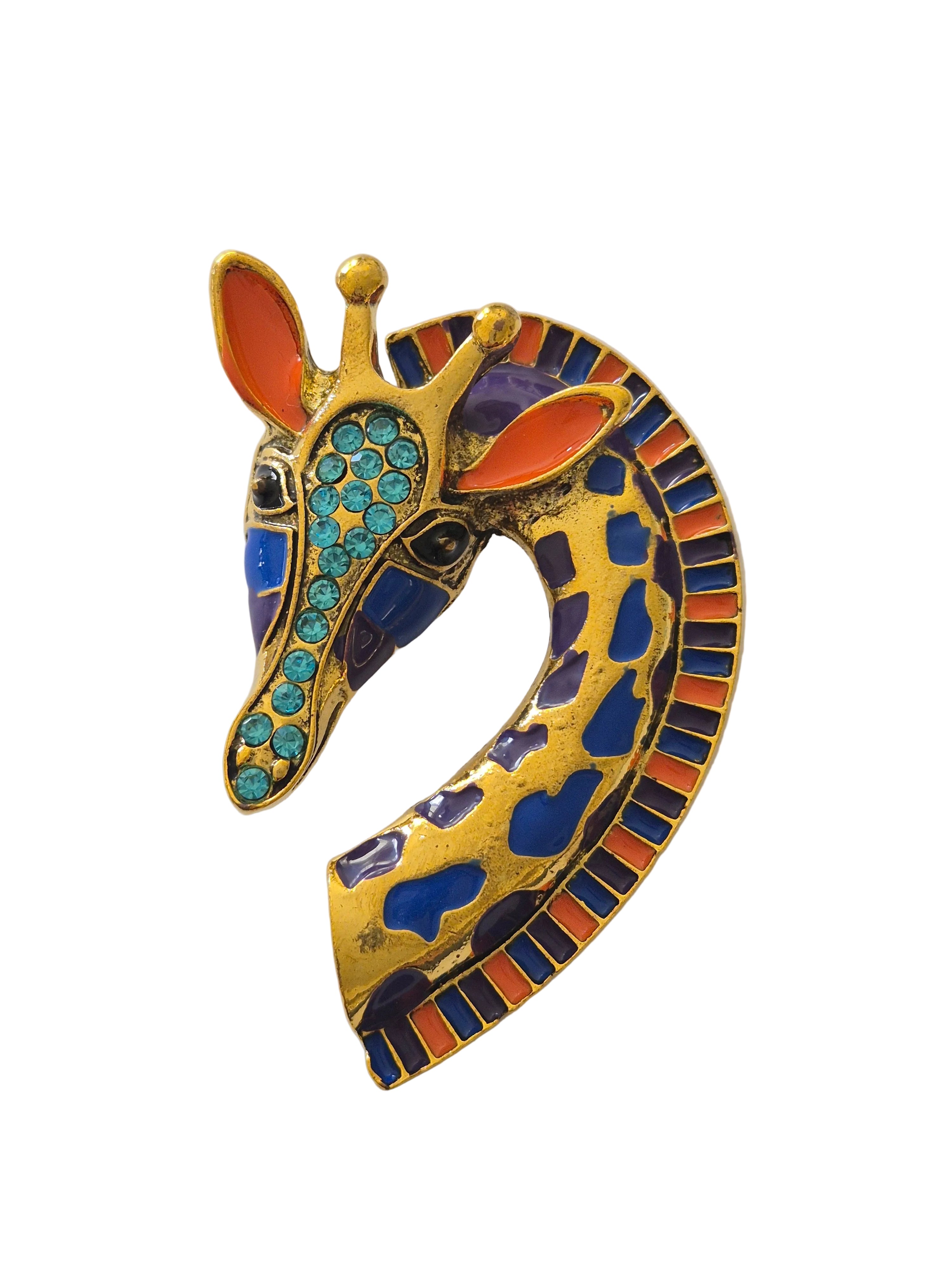 Decorative giraffe brooch with gold, blue, and orange colors on a white background