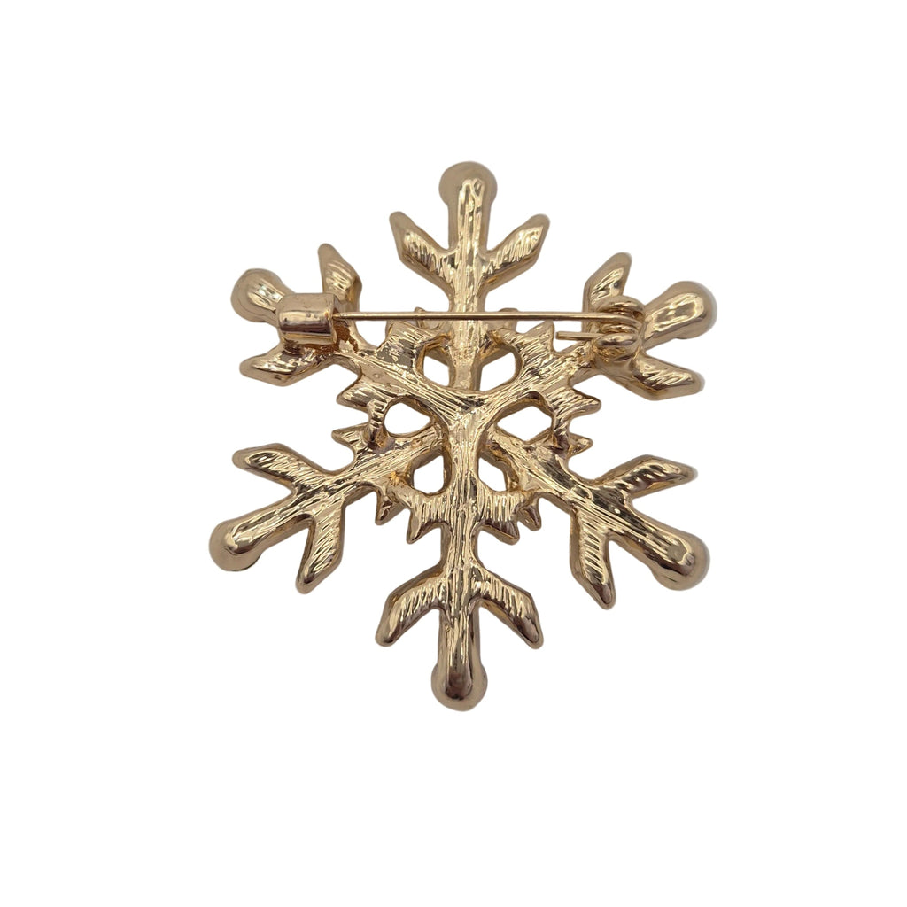 A gold snowflake-shaped brooch with a textured, branch-like design and a pin clasp at the top, shown on a white background.
