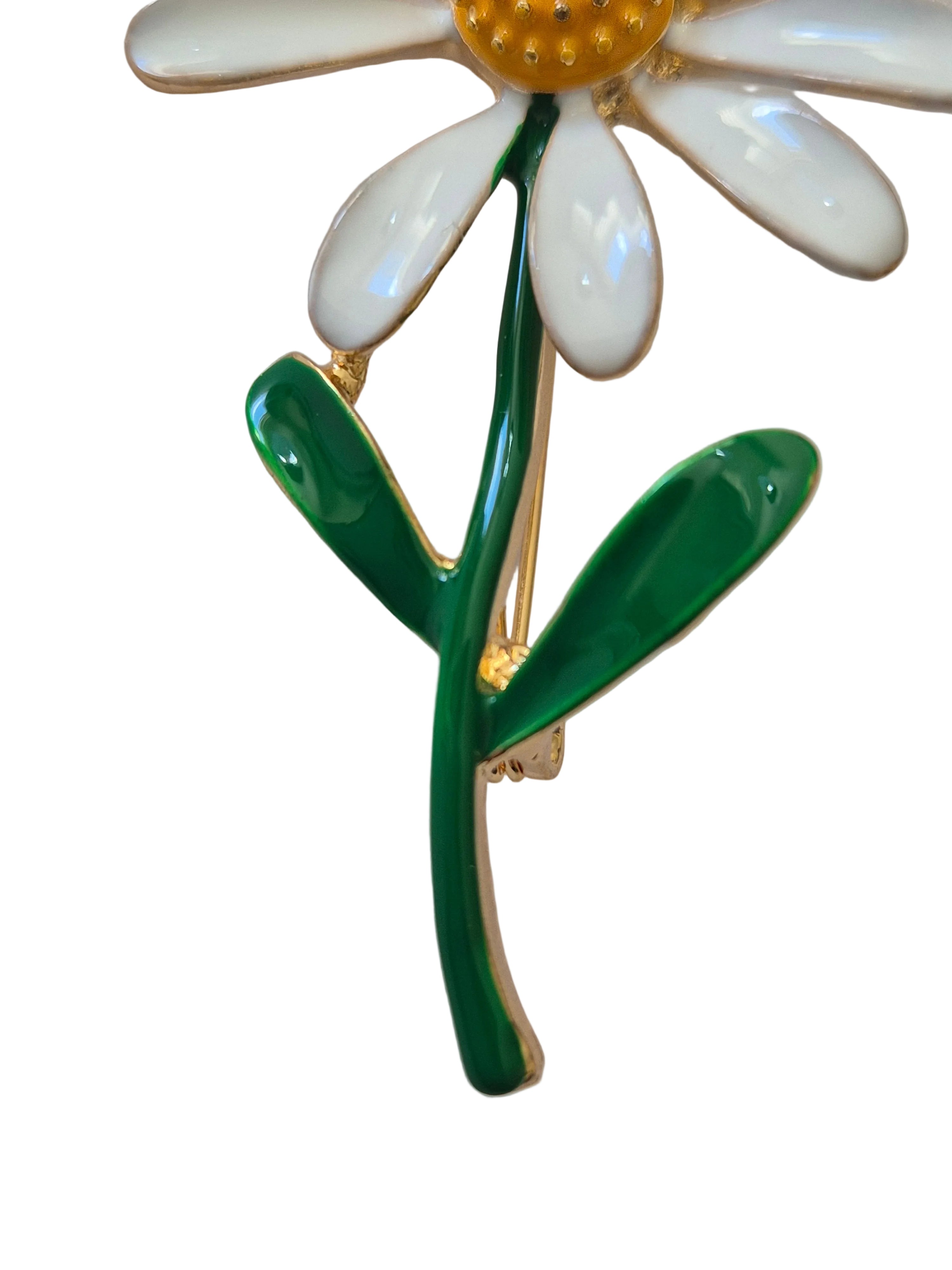 Daisy-shaped brooch with white petals, green stem, and gold center on a white background