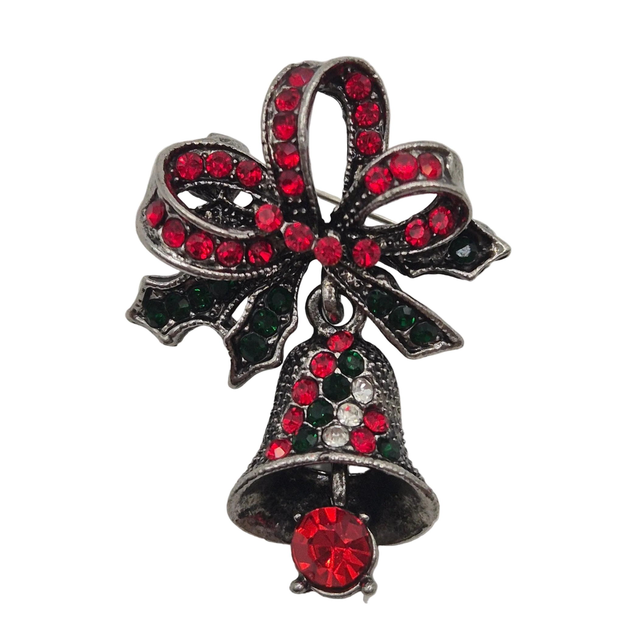A Christmas-themed brooch featuring an ornate silver-tone bow embellished with red and dark green rhinestones, with a dangling silver bell below also decorated with red and green rhinestones and a large red crystal at the bottom.