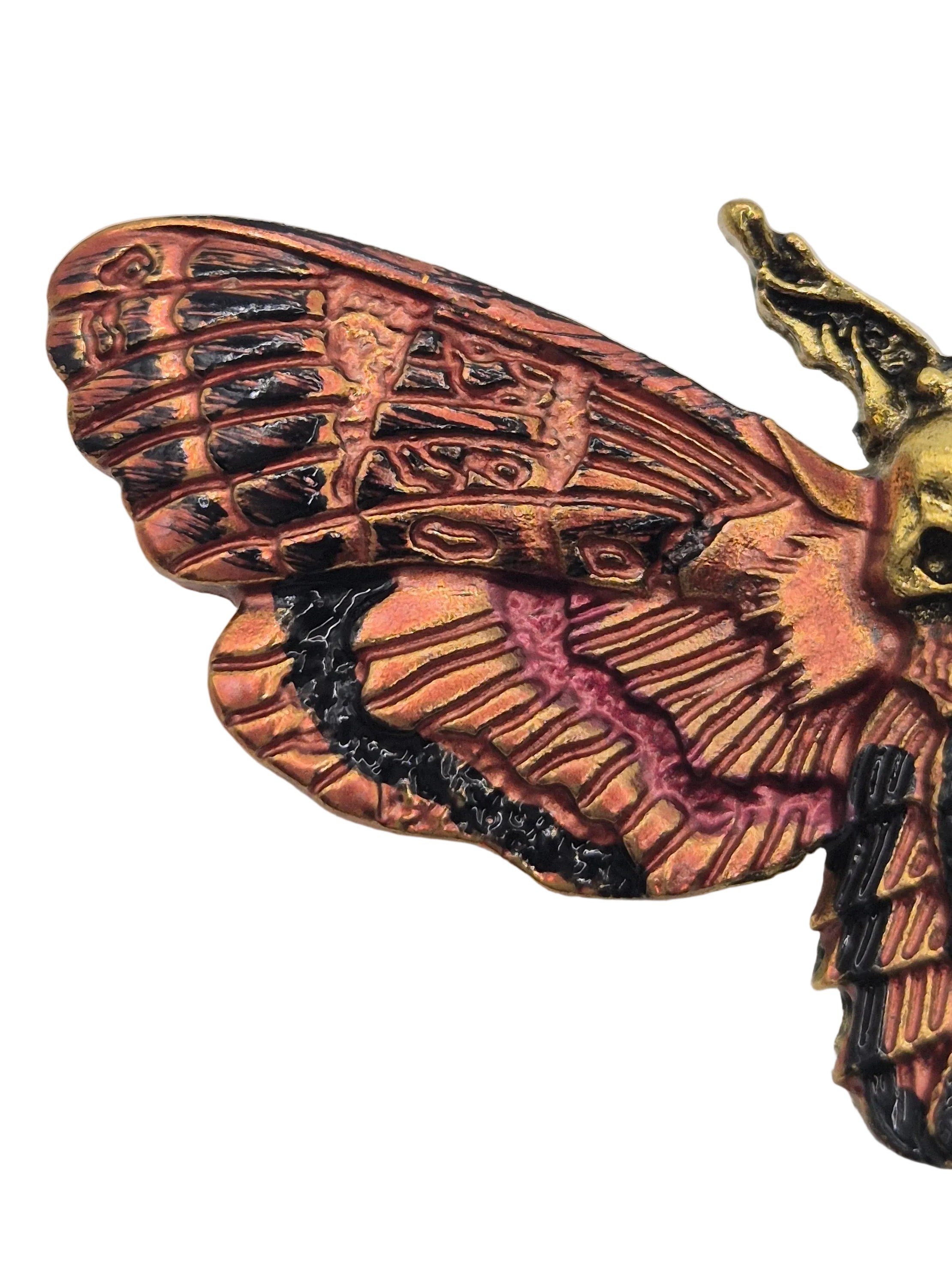 Decorative moth brooch with intricate details on a white background