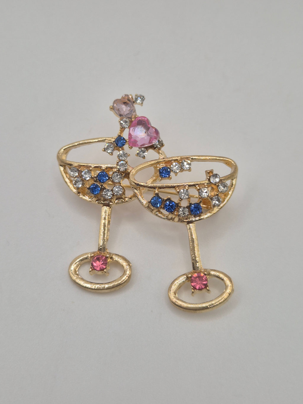 Gold brooch with gemstones on a gray background