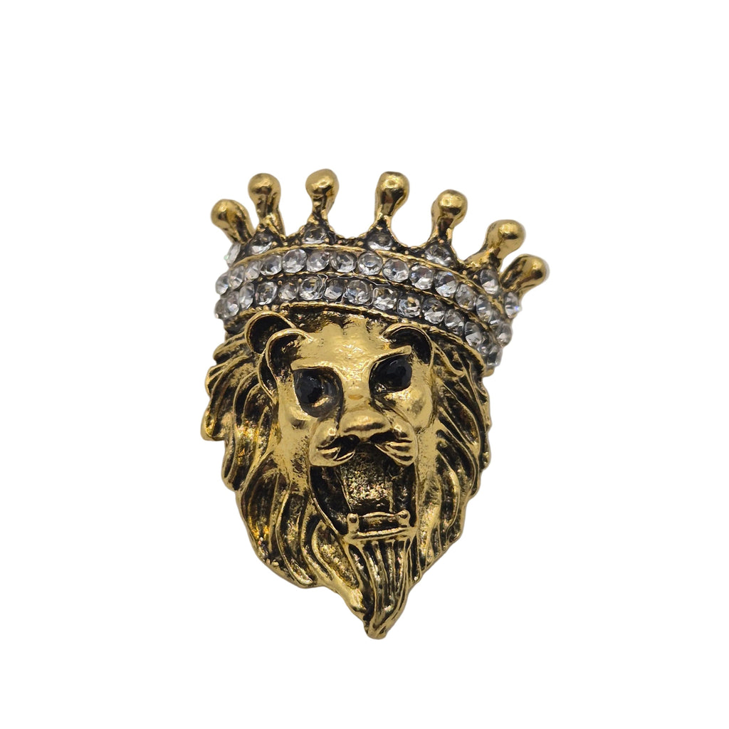 A gold lion head brooch or pin wearing a crown adorned with clear rhinestones, shown against a plain white background.