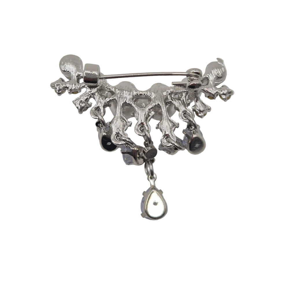 A silver-toned metal brooch featuring a decorative, organic branch-like top with dangling black beads and a teardrop-shaped silver charm, shown on a plain white background.