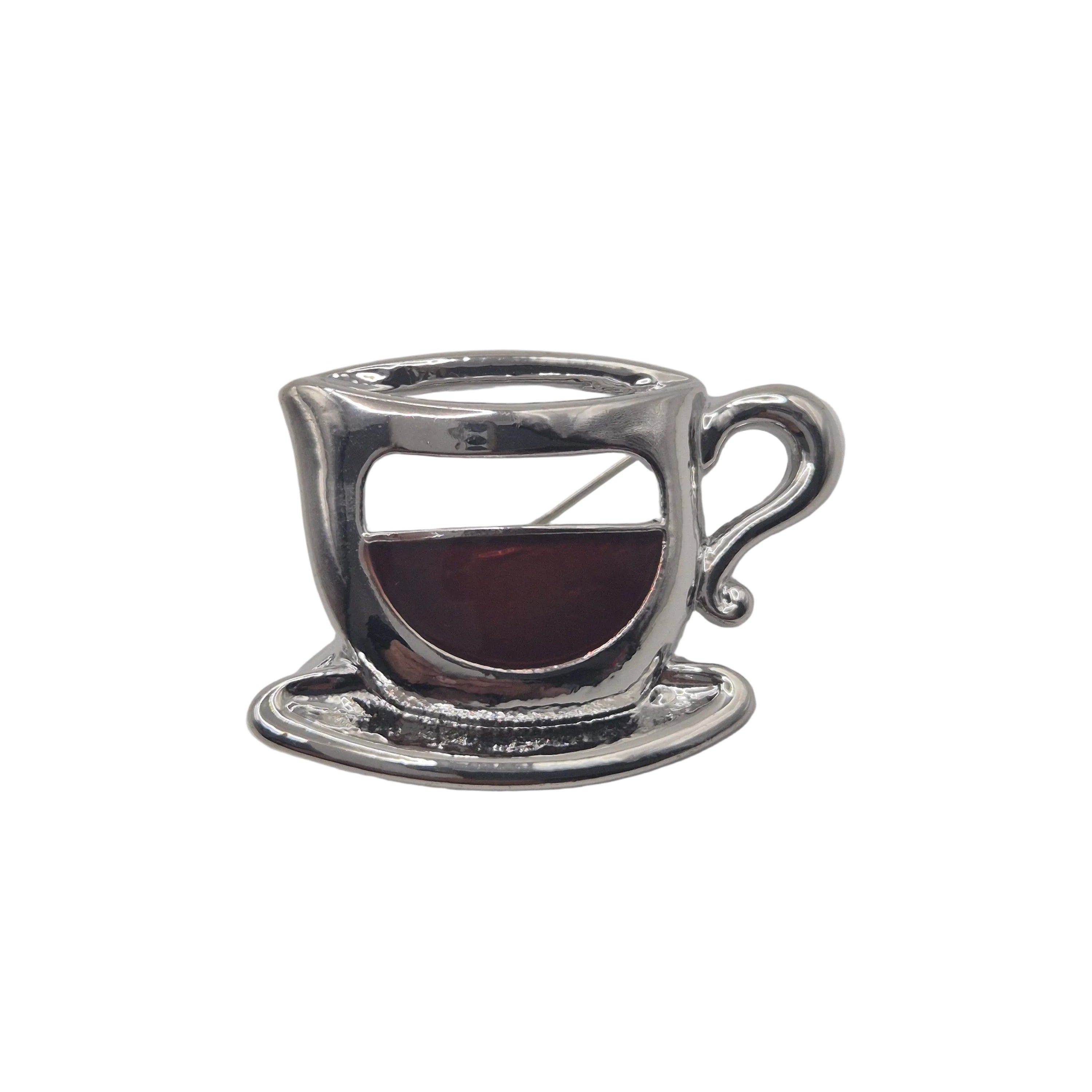 Silver metal coffee cup brooch on white background