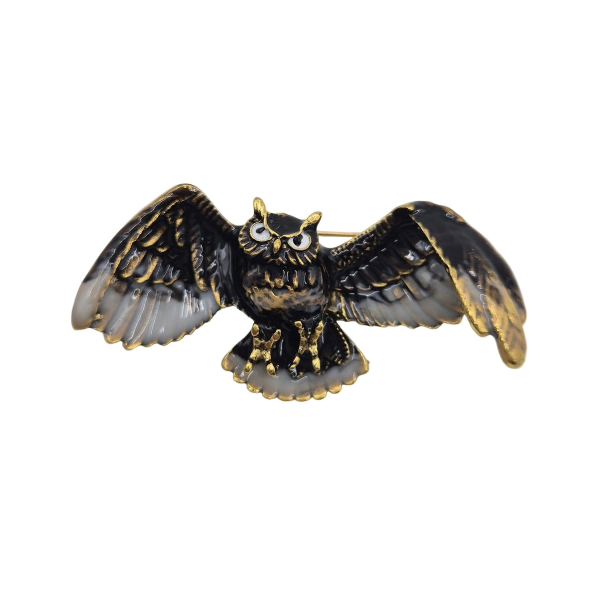 An owl-shaped brooch with black and gold-tone metal detailing, featuring textured wings and a gold-tone beaded outline, photographed on a plain white background.