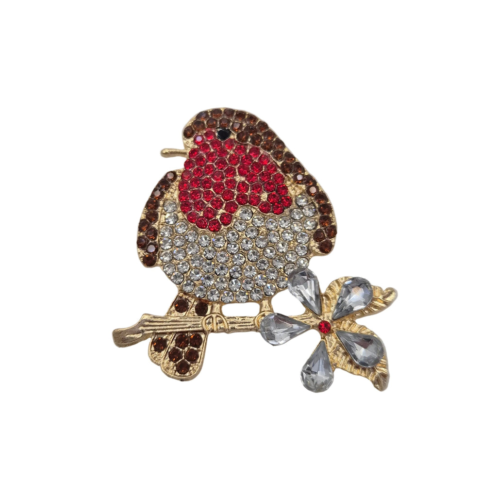 A robin bird brooch embellished with red, clear, and brown rhinestones, perched on a gold branch with a clear crystal flower. Displayed on a plain white background.