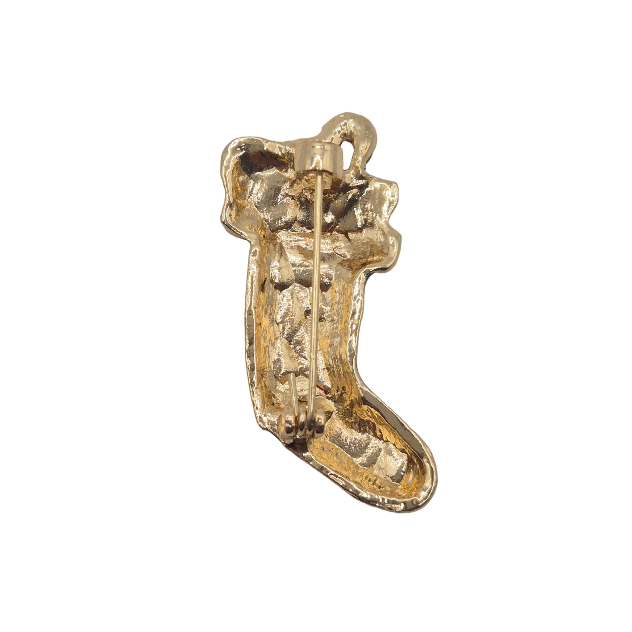 A gold-colored textured boot-shaped brooch with a visible pin mechanism on the back, photographed on plain white background.