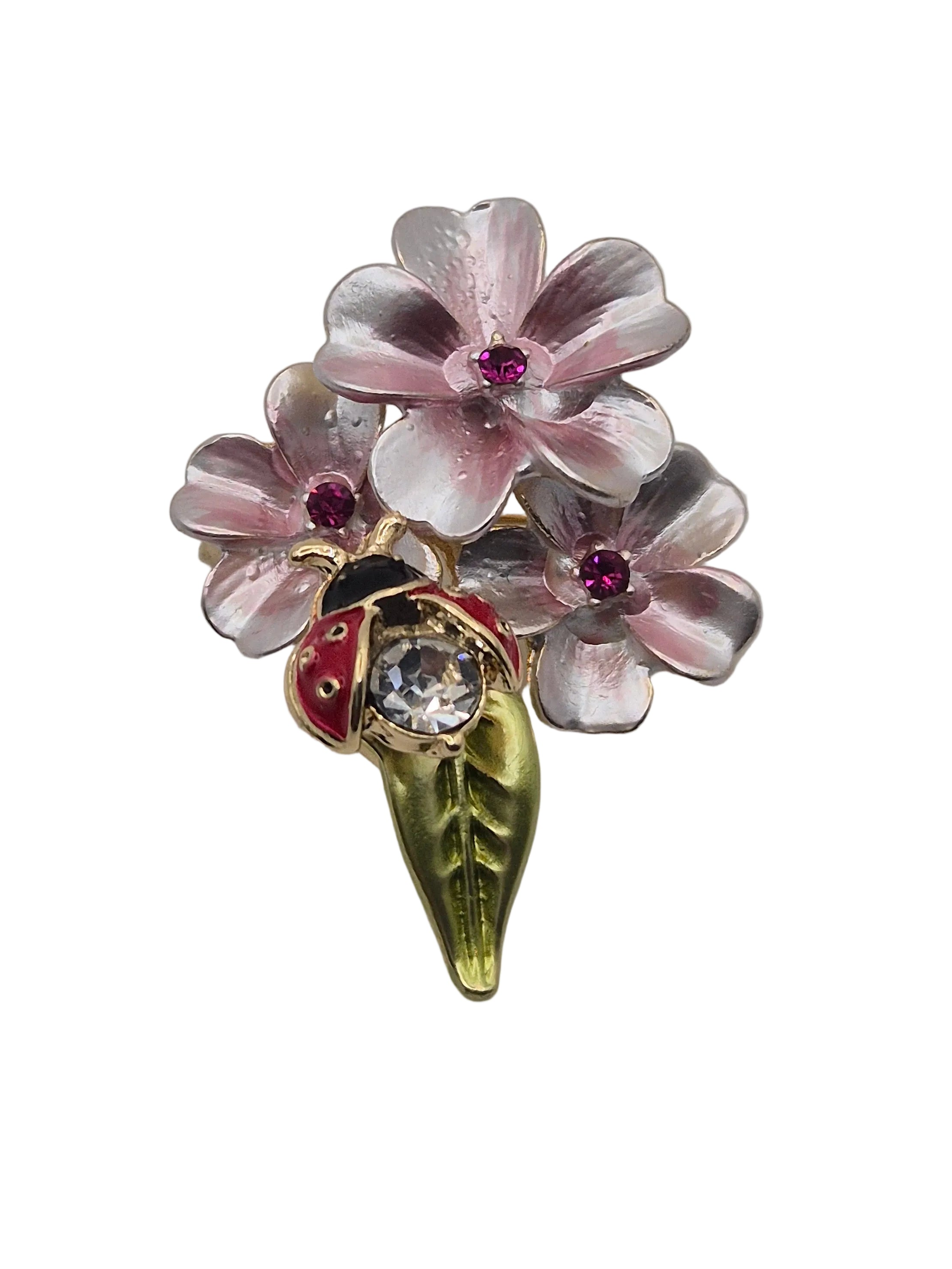 A vintage-style floral brooch featuring three pink and silver cherry blossoms with small red gem accents, a gold leaf stem, and a ladybug detail on a white background.