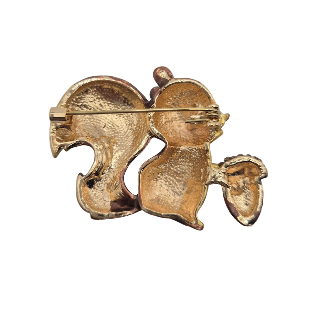 Reverse gold tone side of a squirrel holding an acorn brooch showing pin mechanism, displayed against a plain white background.
