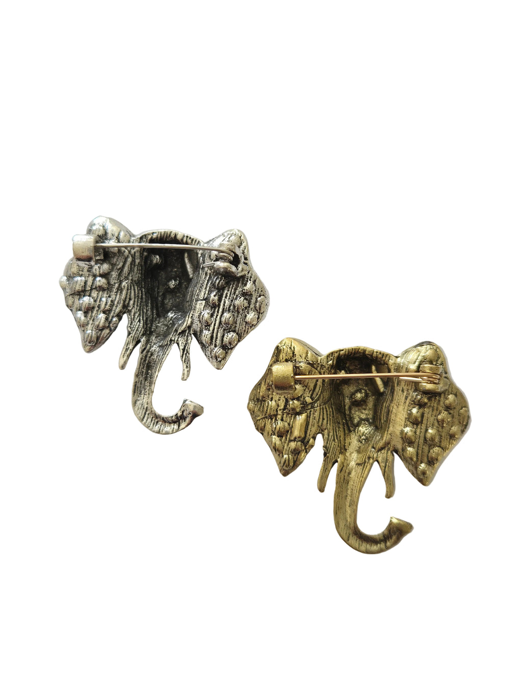 Two elephant-shaped brooches, one gold and one silver, on a light gray background.