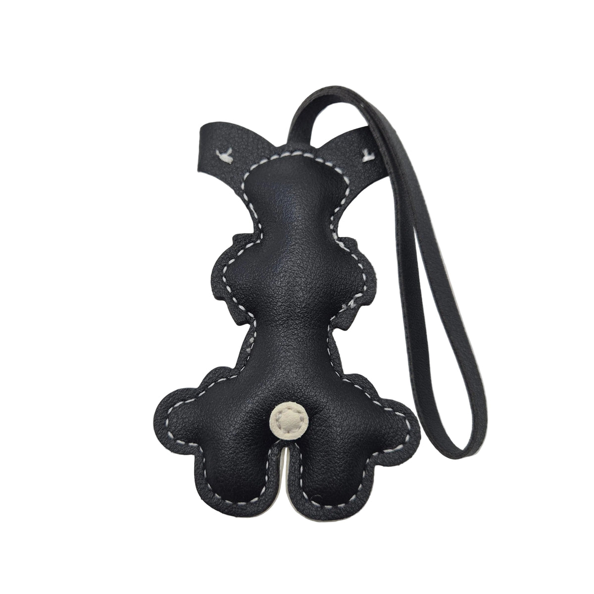 A small dog-shaped leather keychain or bag charm with a black and cream colour scheme, featuring a loop strap at the top, photographed on a white background showing the reverse side.