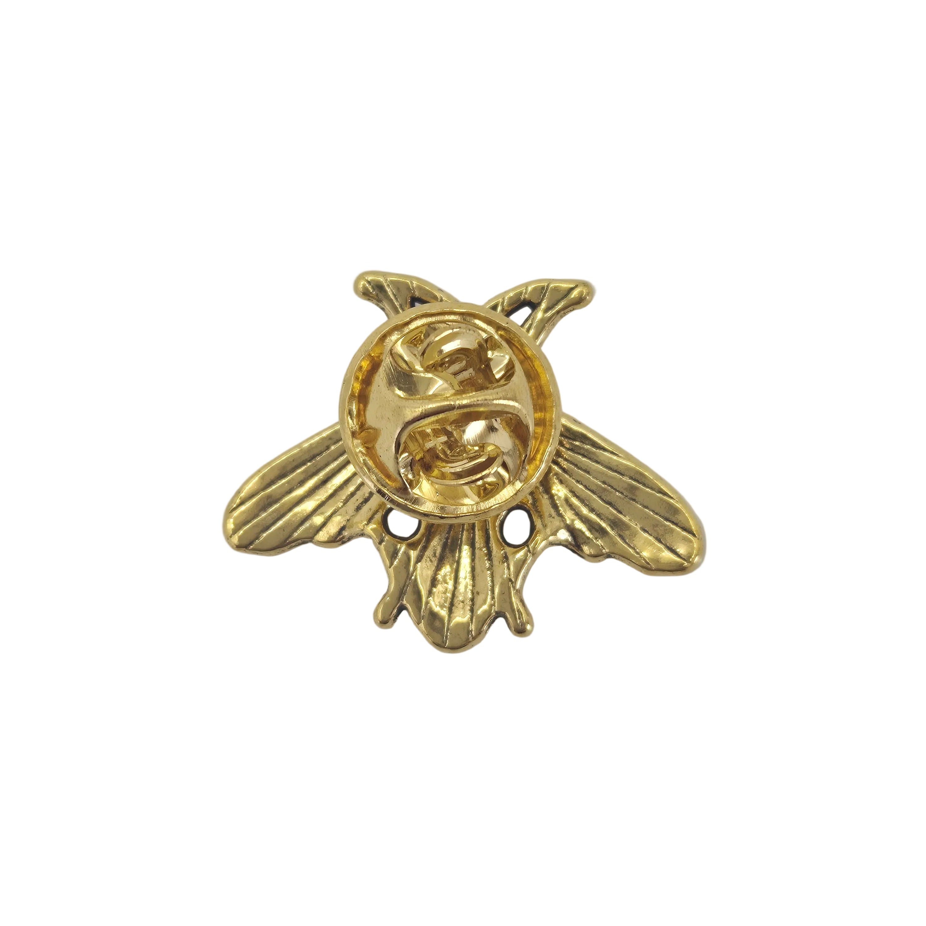 A small gold bee-shaped metal charm or brooch with a circular pin-back back, shown on a plain white background.