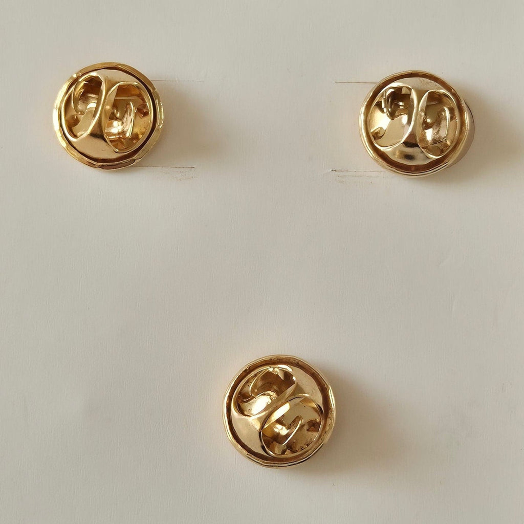 Reverse side of 3 Christmas pins showing butterfly clasp fastening, displayed against a plain white background.