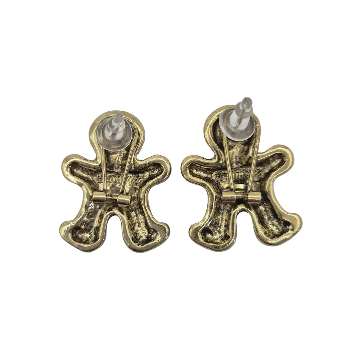 A pair of small gingerbread man stud earrings with an antique gold finish and clear plastic backing, shown on a plain white  background.