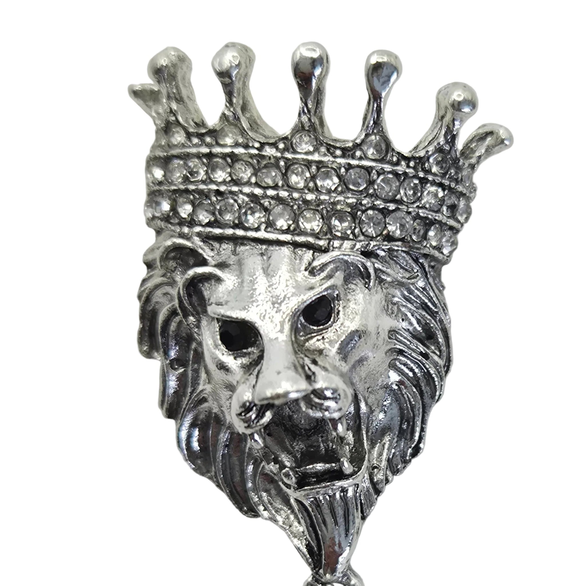 Silver-tone lion head brooch with a crown and dangling chains, shown on a  white background, displaying rhinestone detailing.