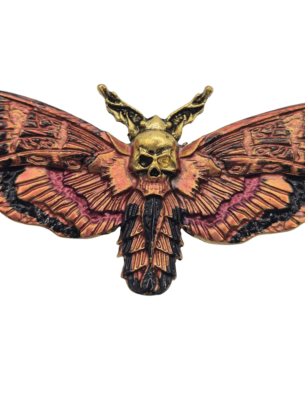 Decorative moth brooch with intricate patterns on a plain background