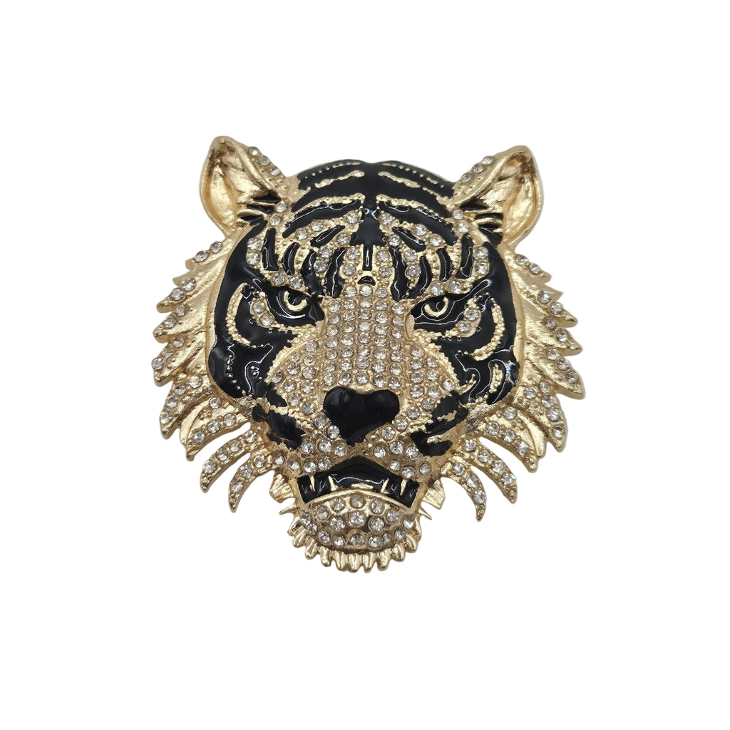 A gold and black tiger head brooch embellished with clear rhinestones, shown against a plain white background.