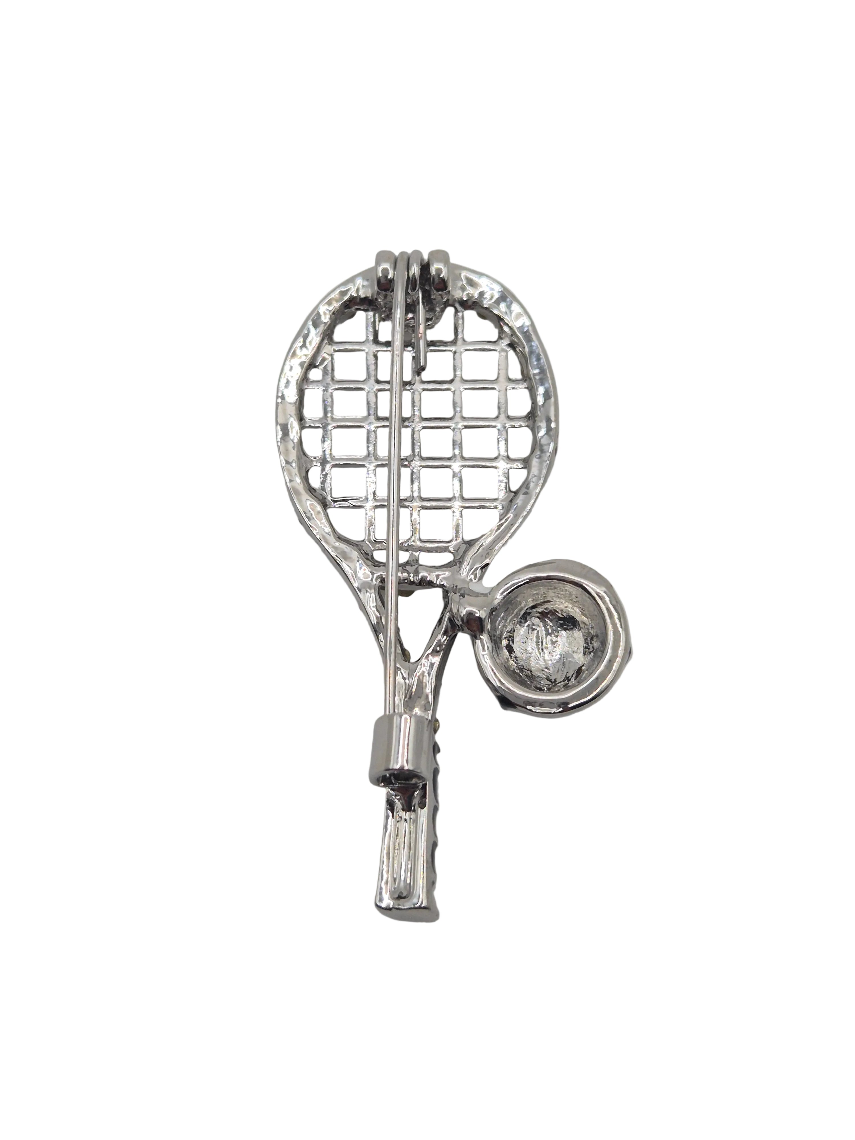 Silver tennis racket and ball brooch on a white background