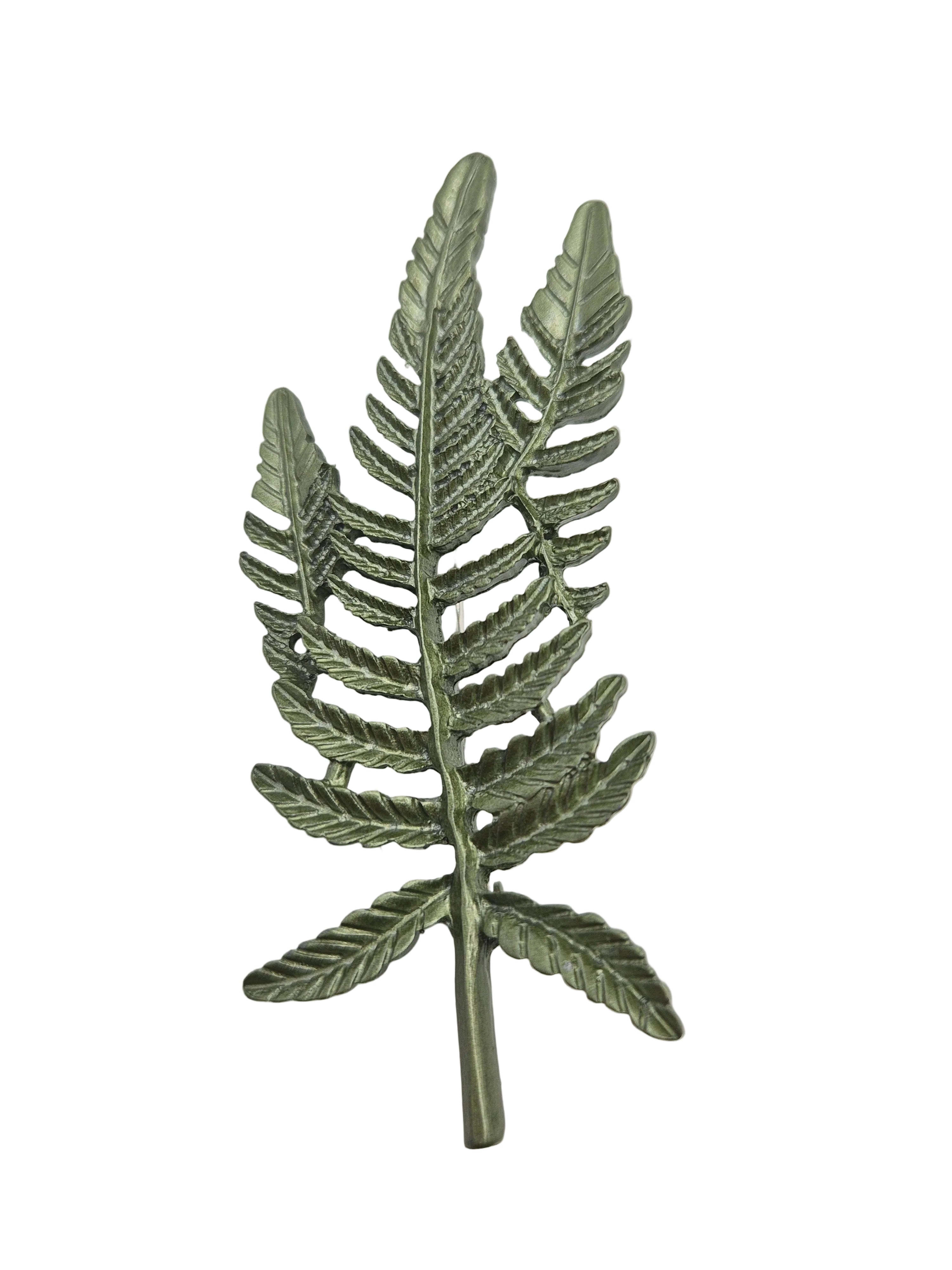 Close up of green fern leaves brooch on a plain white background. 