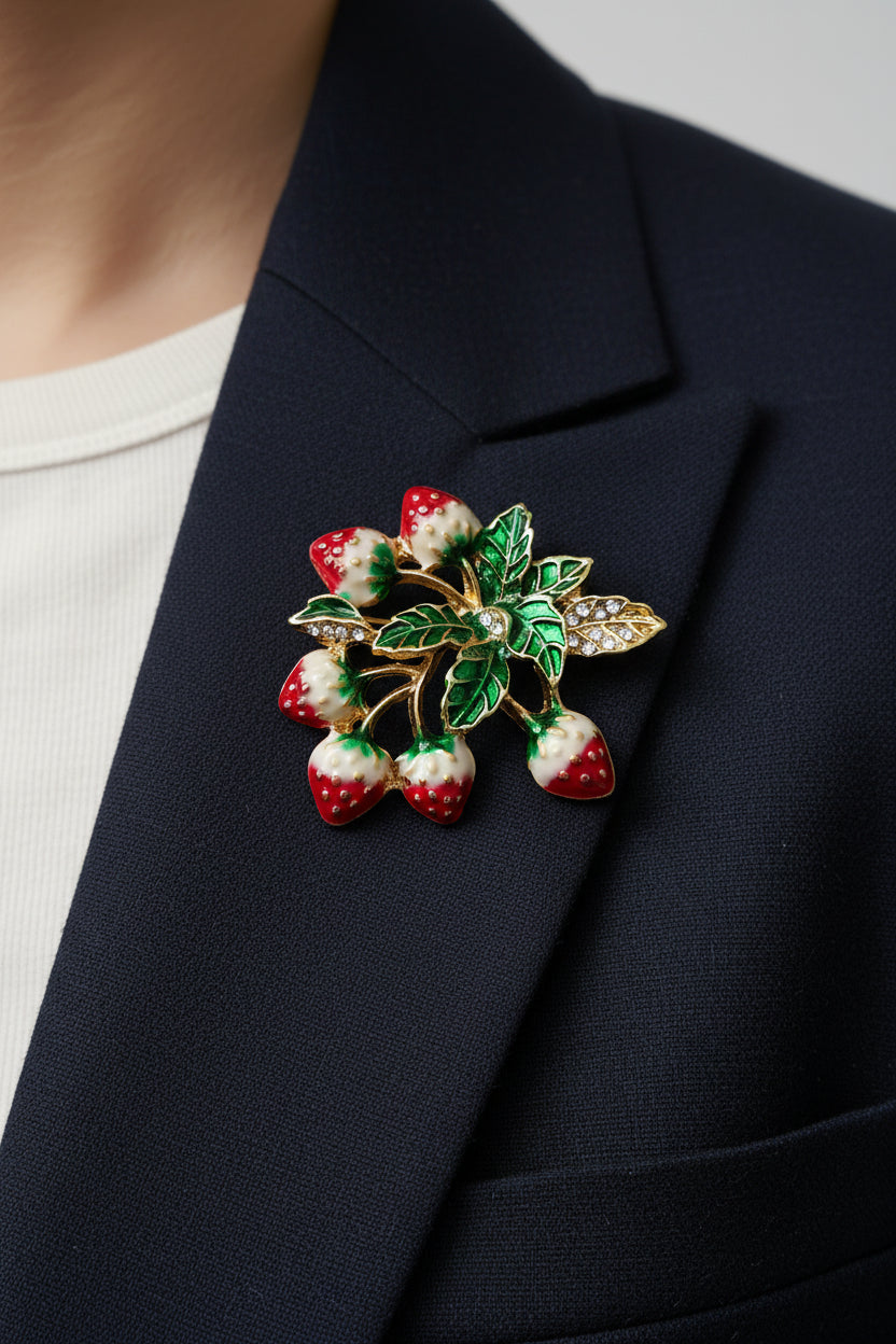 Decorative brooch with strawberry and leaf design on a light gray background