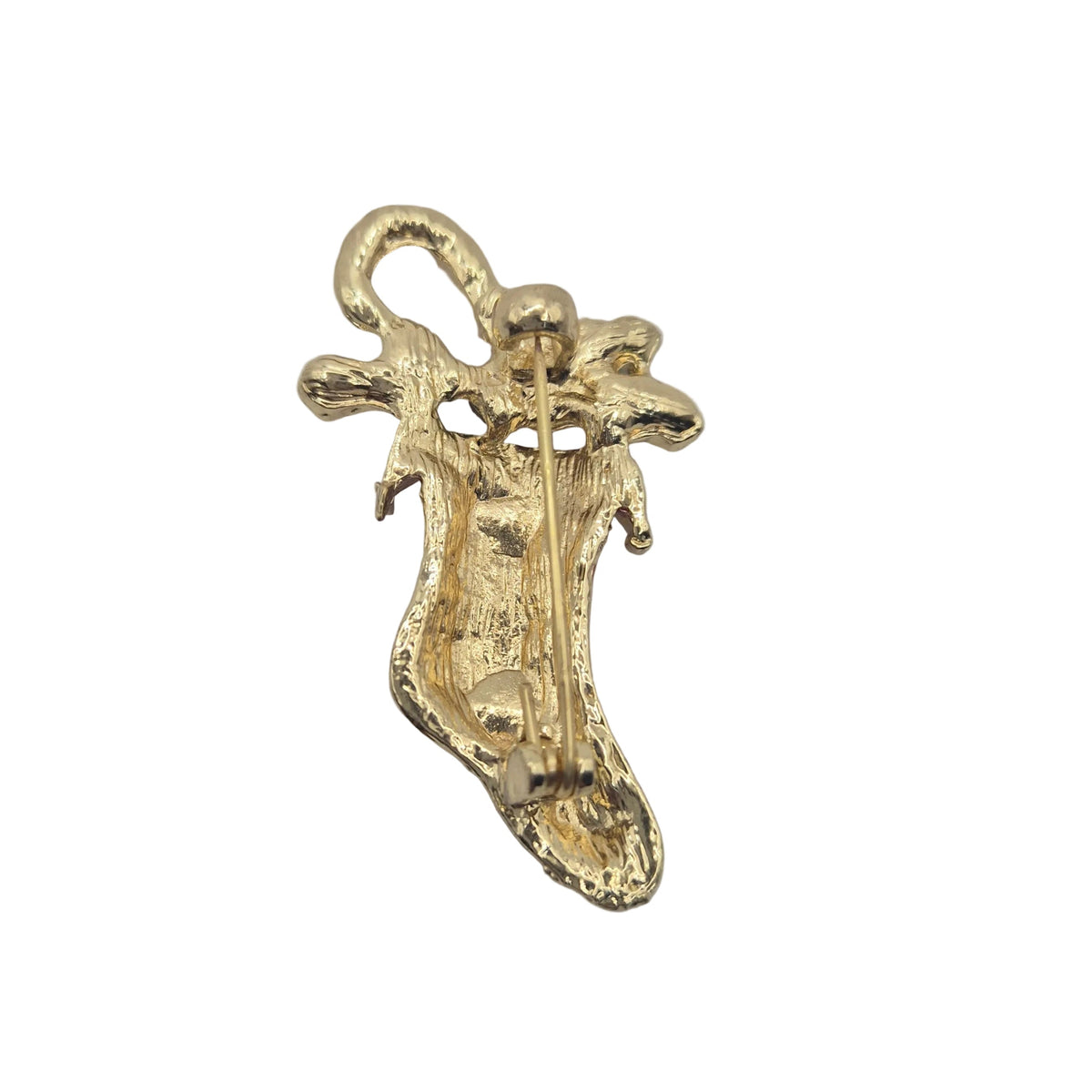 Reverse gold tone side of a Christmas stocking brooch showing the pin mechanism, displayed on a plain white background.
