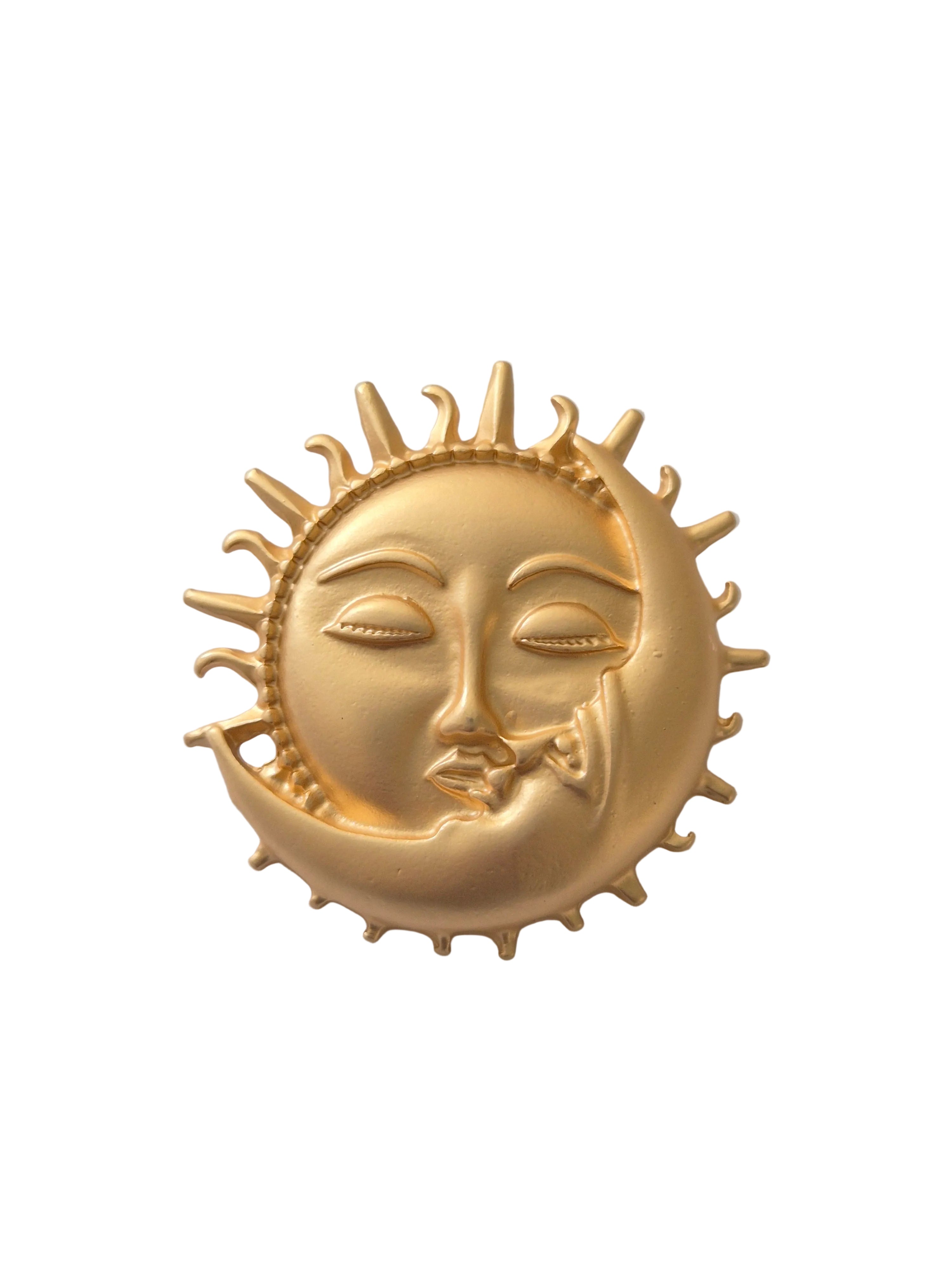Gold sun and moon face brooch on a white background