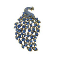 A peacock-shaped brooch featuring blue rhinestones set in gold-tone metal, displayed on a plain white background.