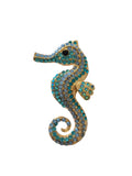 Seahorse-shaped brooch with blue gemstones on a white background