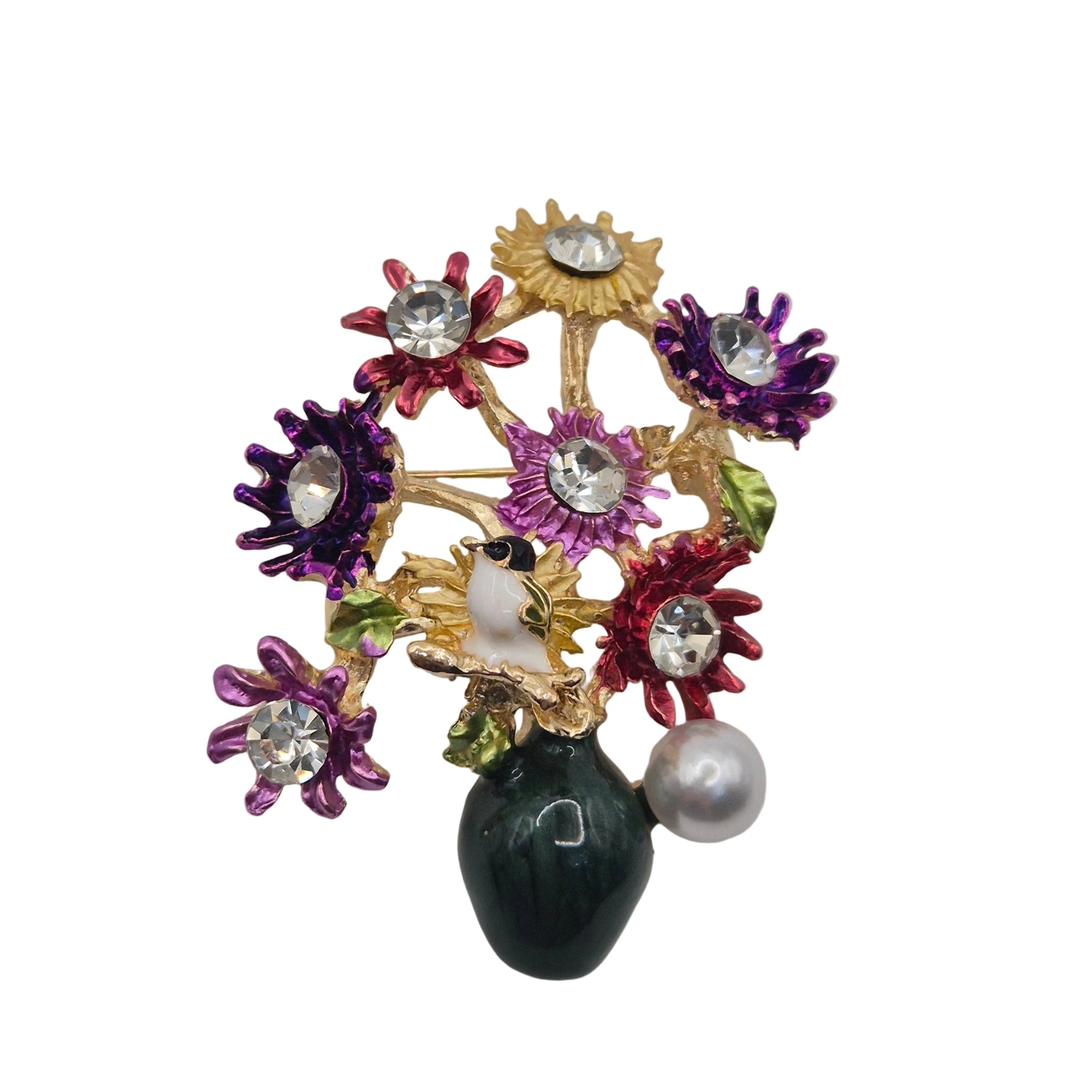A vintage-style floral enamel brooch featuring gold-tone metal, purple, red, and yellow enamel flowers, clear rhinestones, a white pearl, and a dark green teardrop-shaped bead on a plain light gray background.