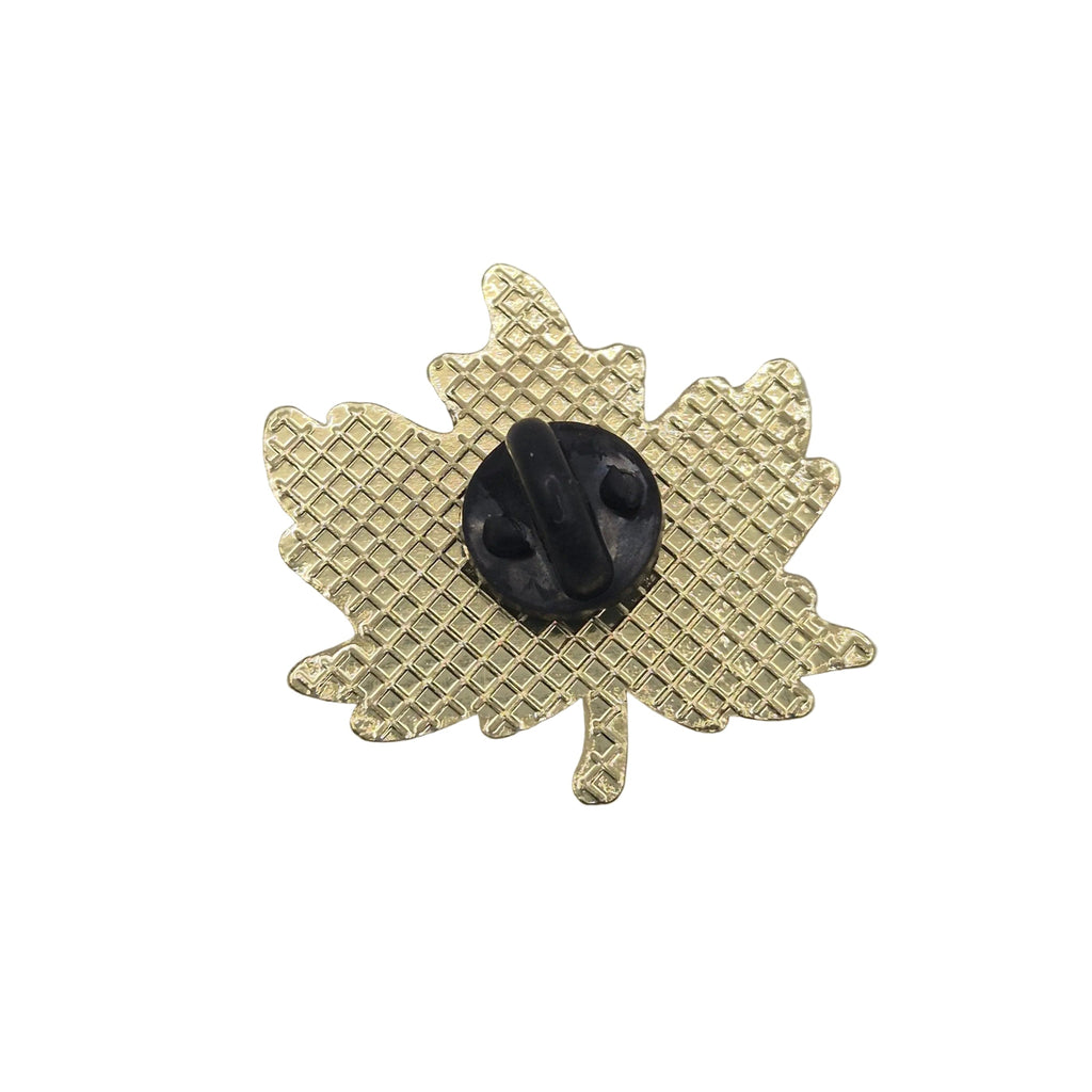 A gold maple leaf-shaped brooch with a textured grid pattern and a central black oval stone, shown on a plain white background.
