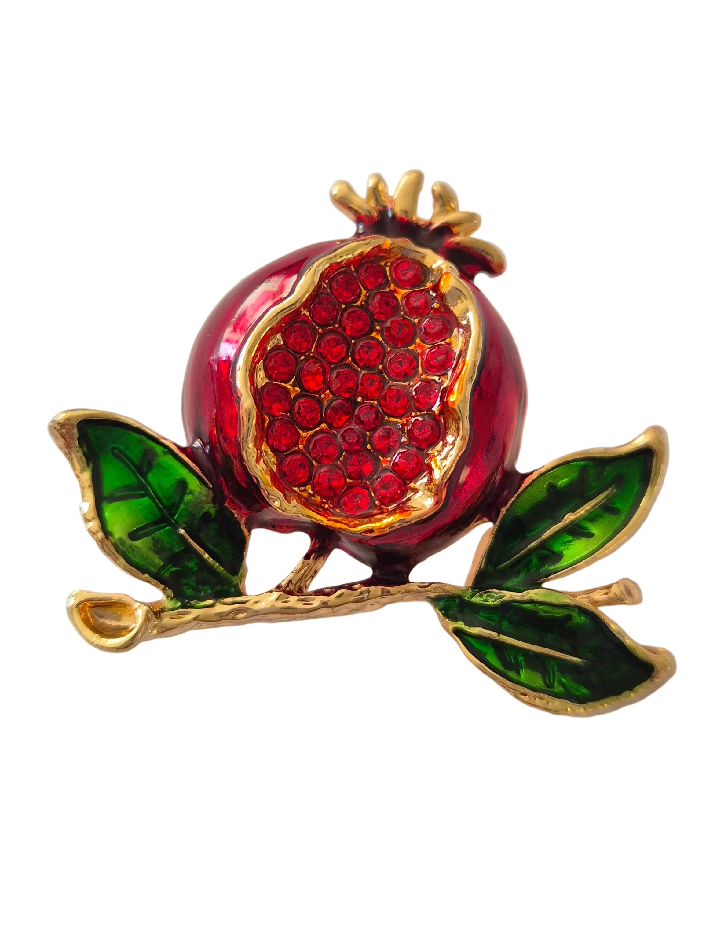 Pomegranate brooch with red gemstones and green leaves on a white background