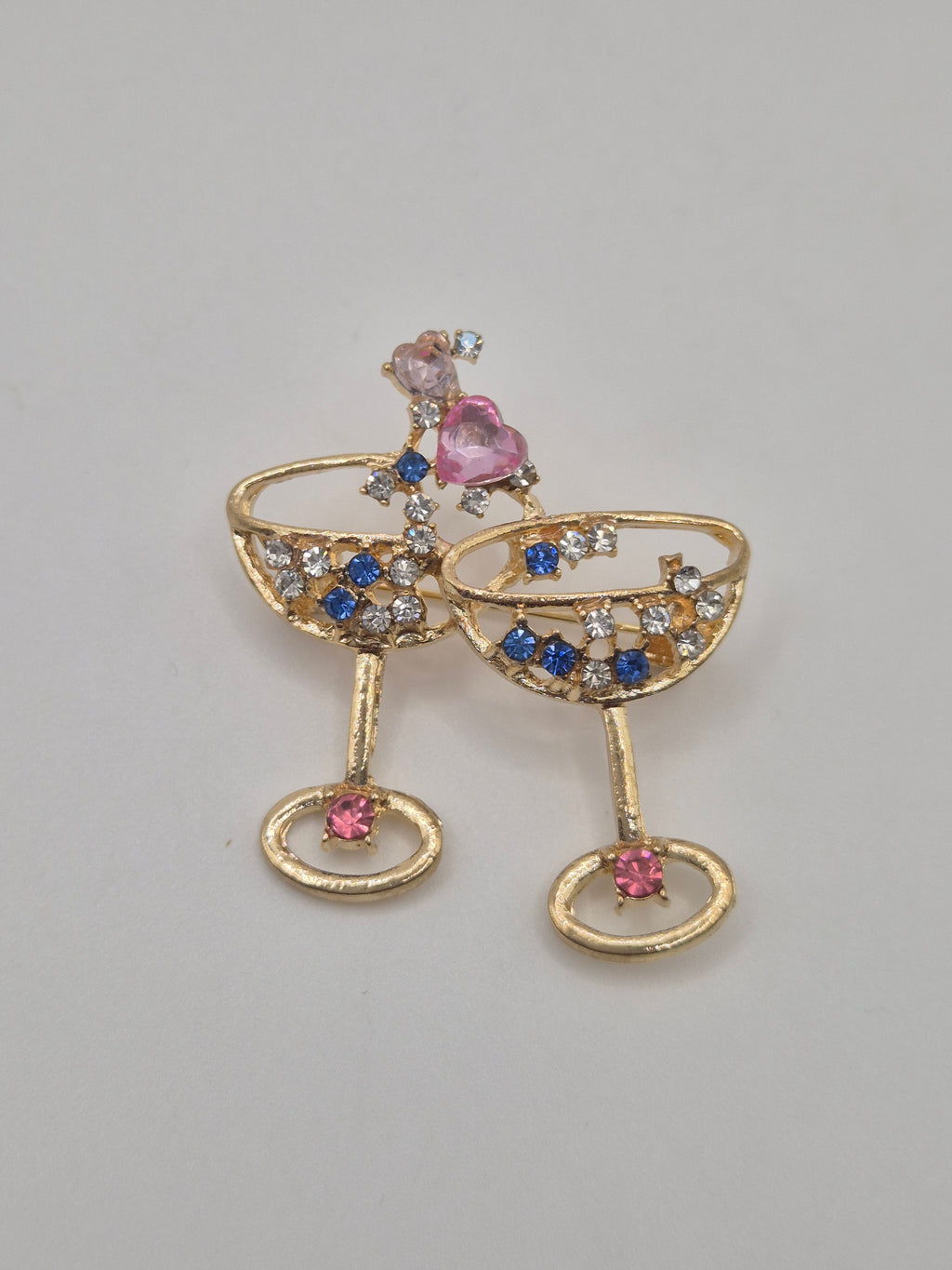 Gold brooch with gemstones on a gray background