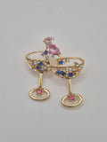 Gold brooch with gemstones on a gray background