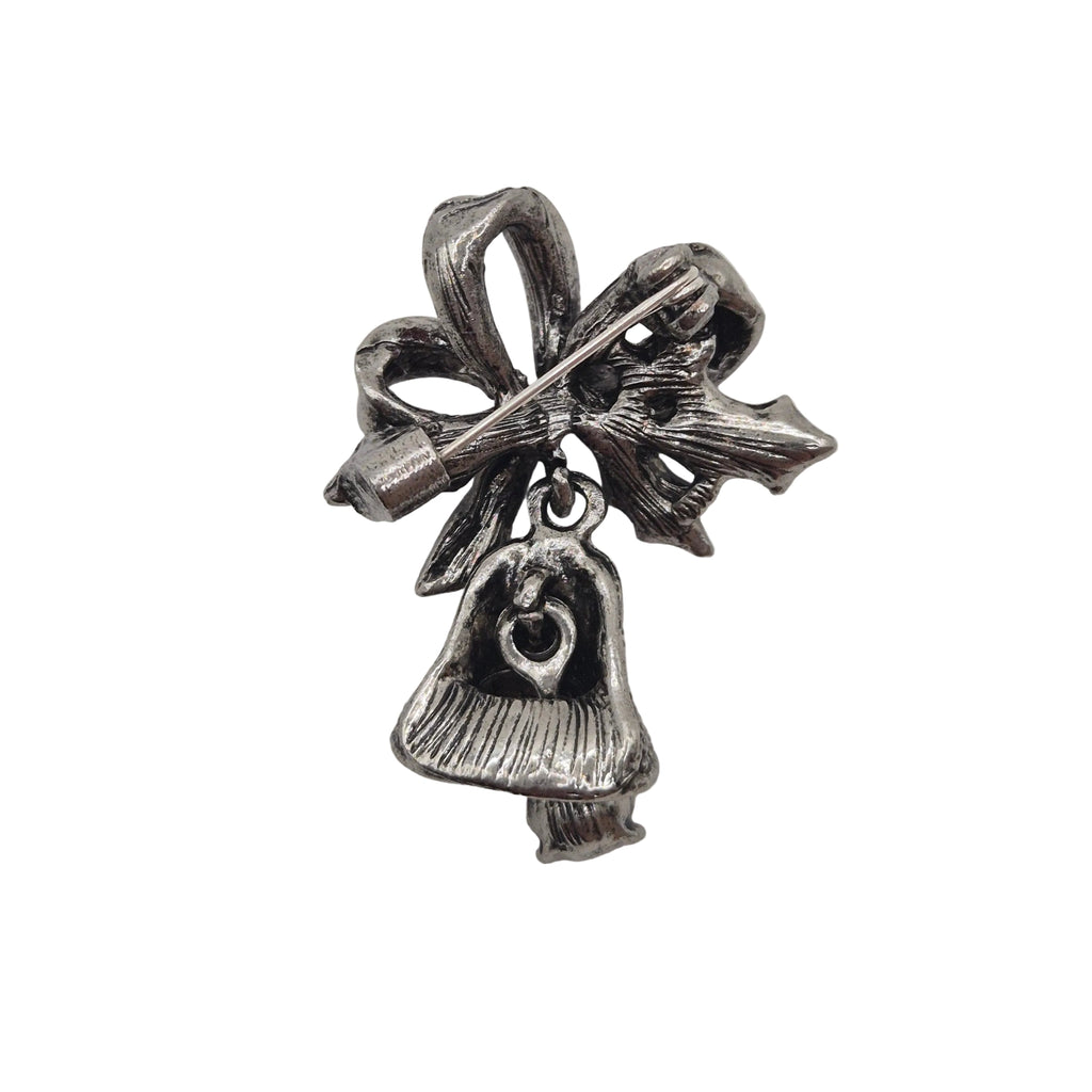 A silver-toned Christmas ornament charm featuring a bow, star, and bell with a heart detail, shown on a plain white background.