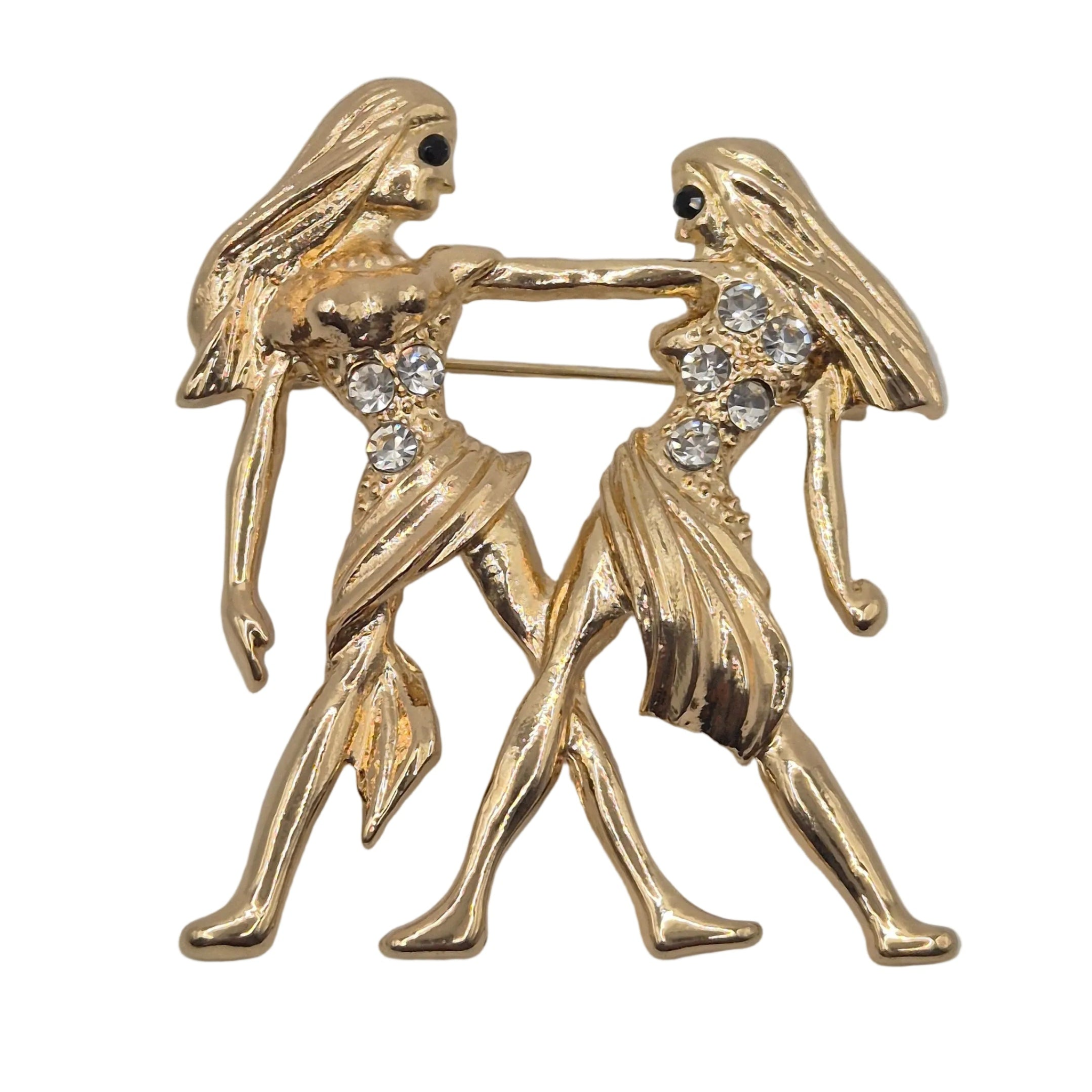 A gold tone Gemini zodiac sign brooch with rhinestone detailing. Shown against a plain white background.