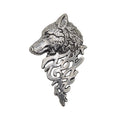 A silver-toned metal brooch featuring a detailed wolf head in profile with ornate scrollwork below, shown on a plain white background.
