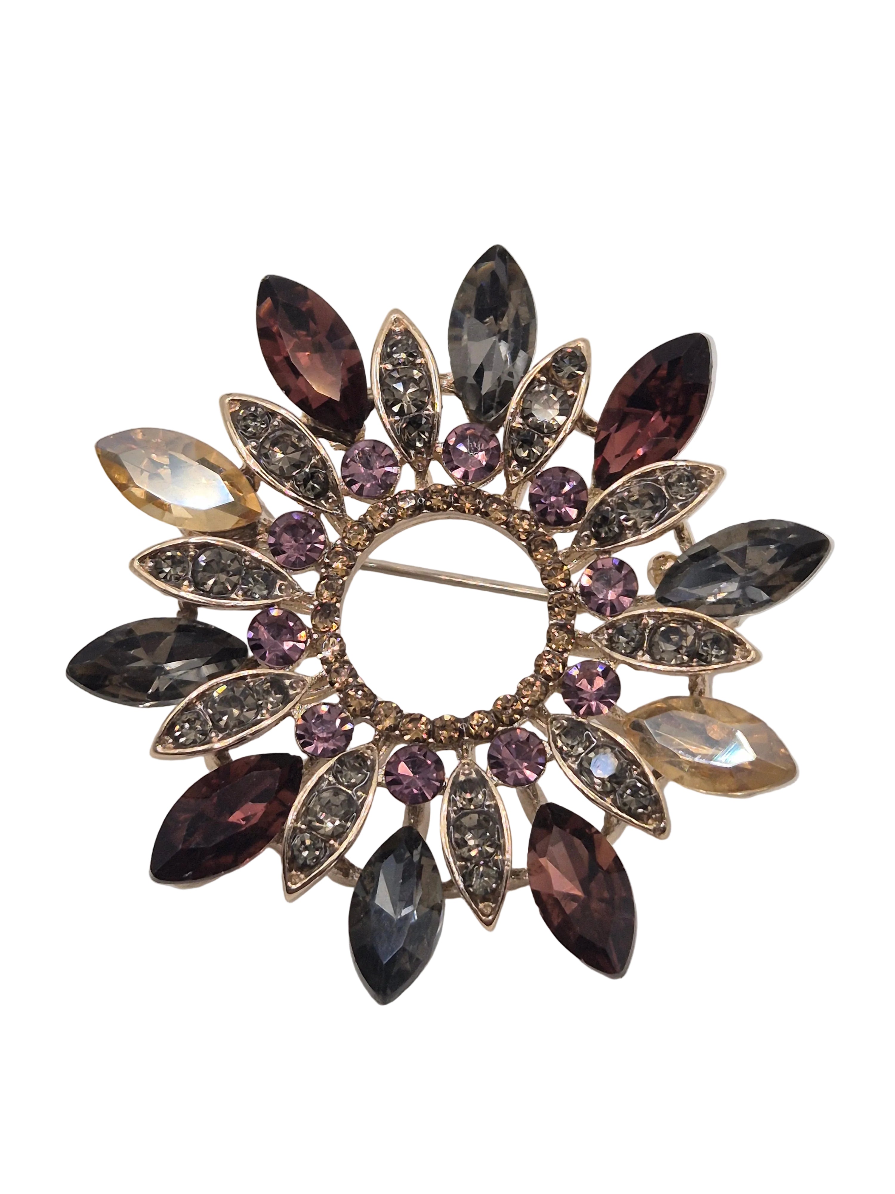 Decorative wreath brooch with multicolored gemstones on a white background