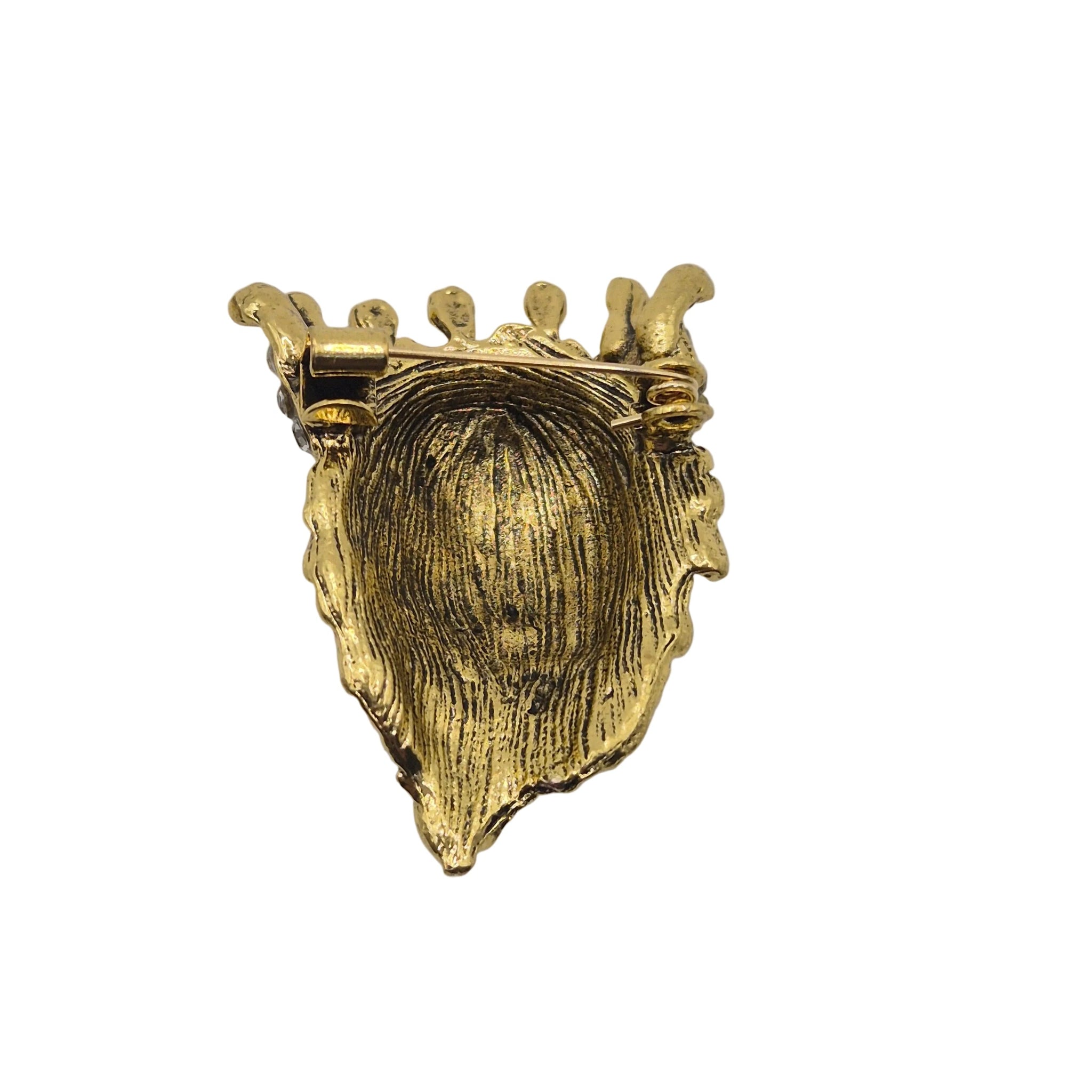 A gold lion head brooch pin wearing a crown adorned with clear rhinestones, shown against a plain white background.