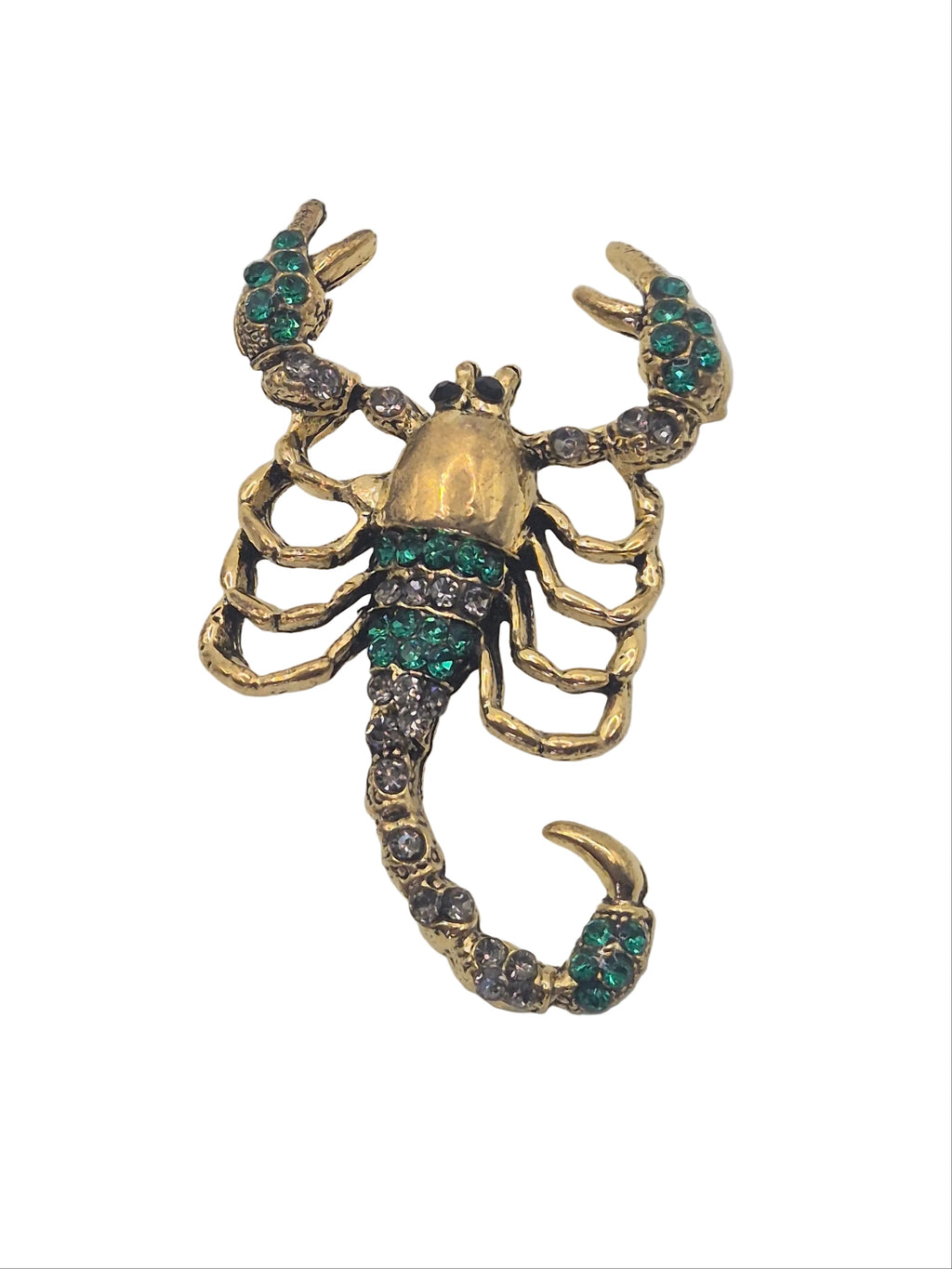 A gold metal scorpion brooch embellished with green rhinestones, shown against a plain white background