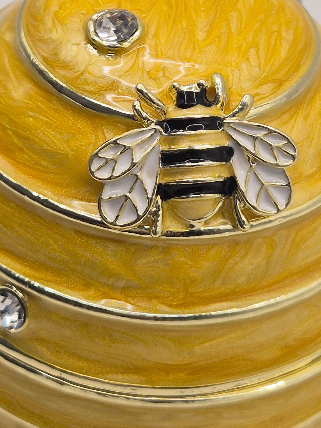 bee hive trinket pot resembling a honeycomb with a bee emblem on a light gray background