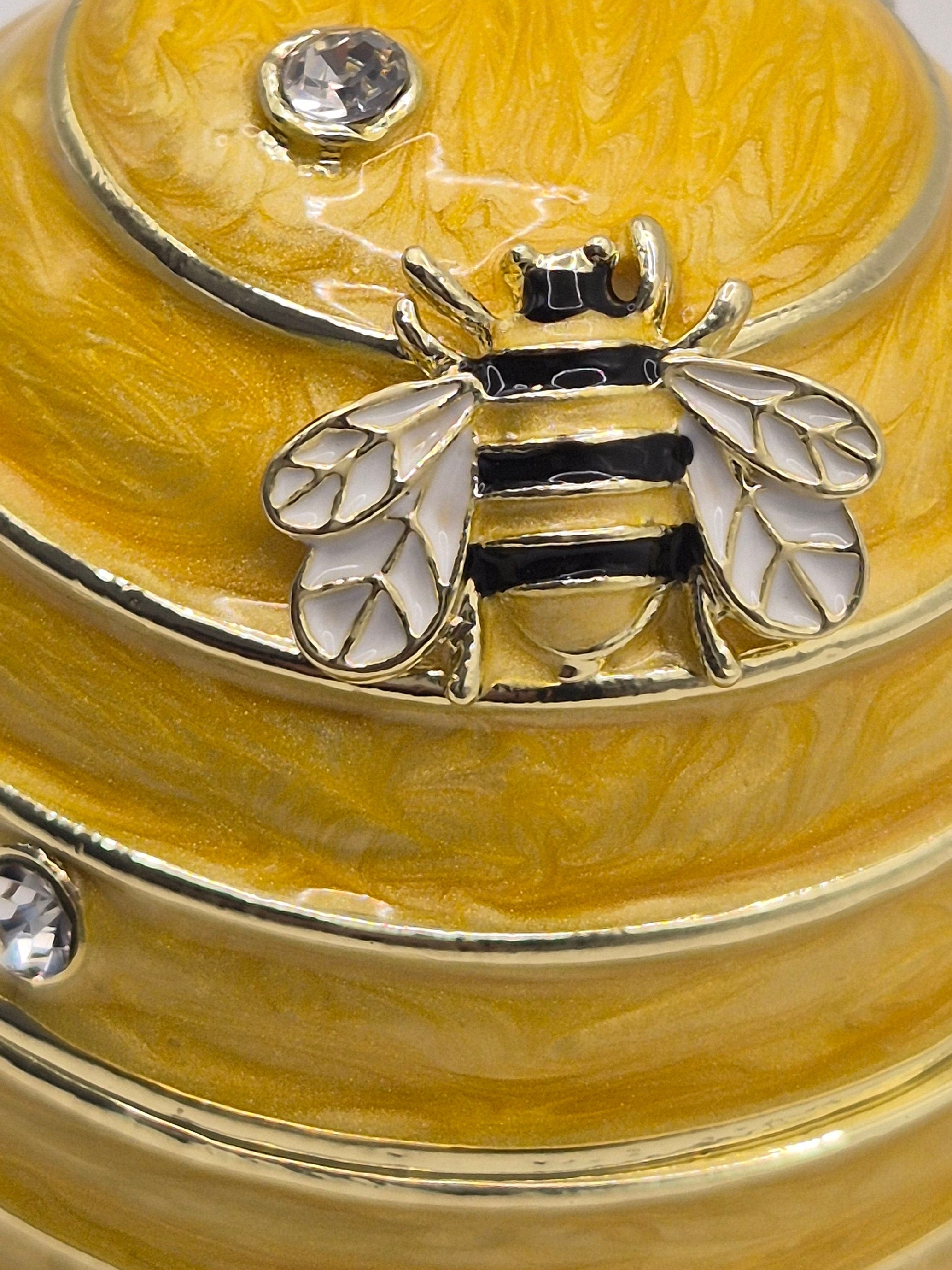 bee hive trinket pot resembling a honeycomb with a bee emblem on a light gray background