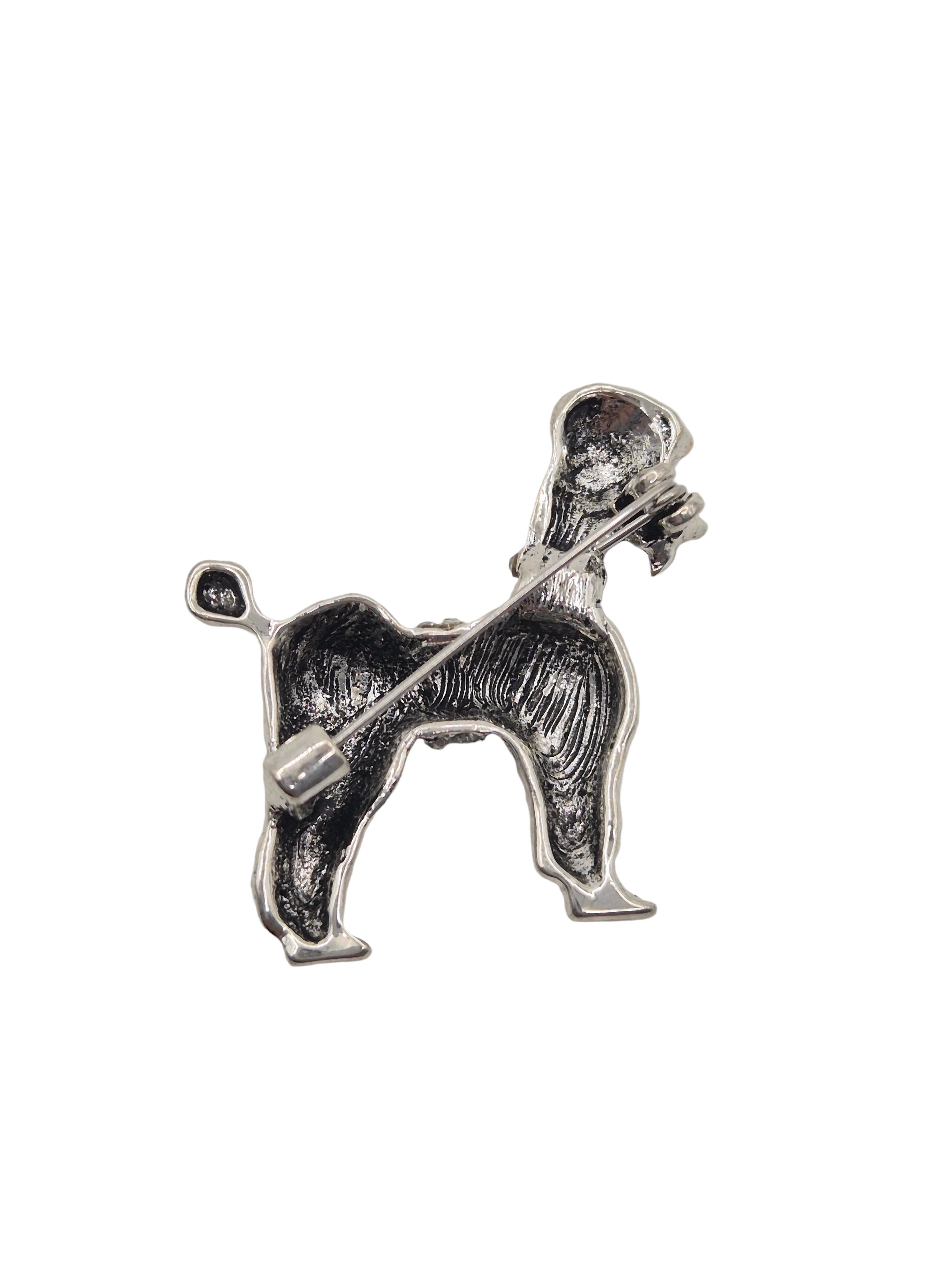 A silver-tone metal dog-shaped brooch or pin, shown in profile against a plain white background.