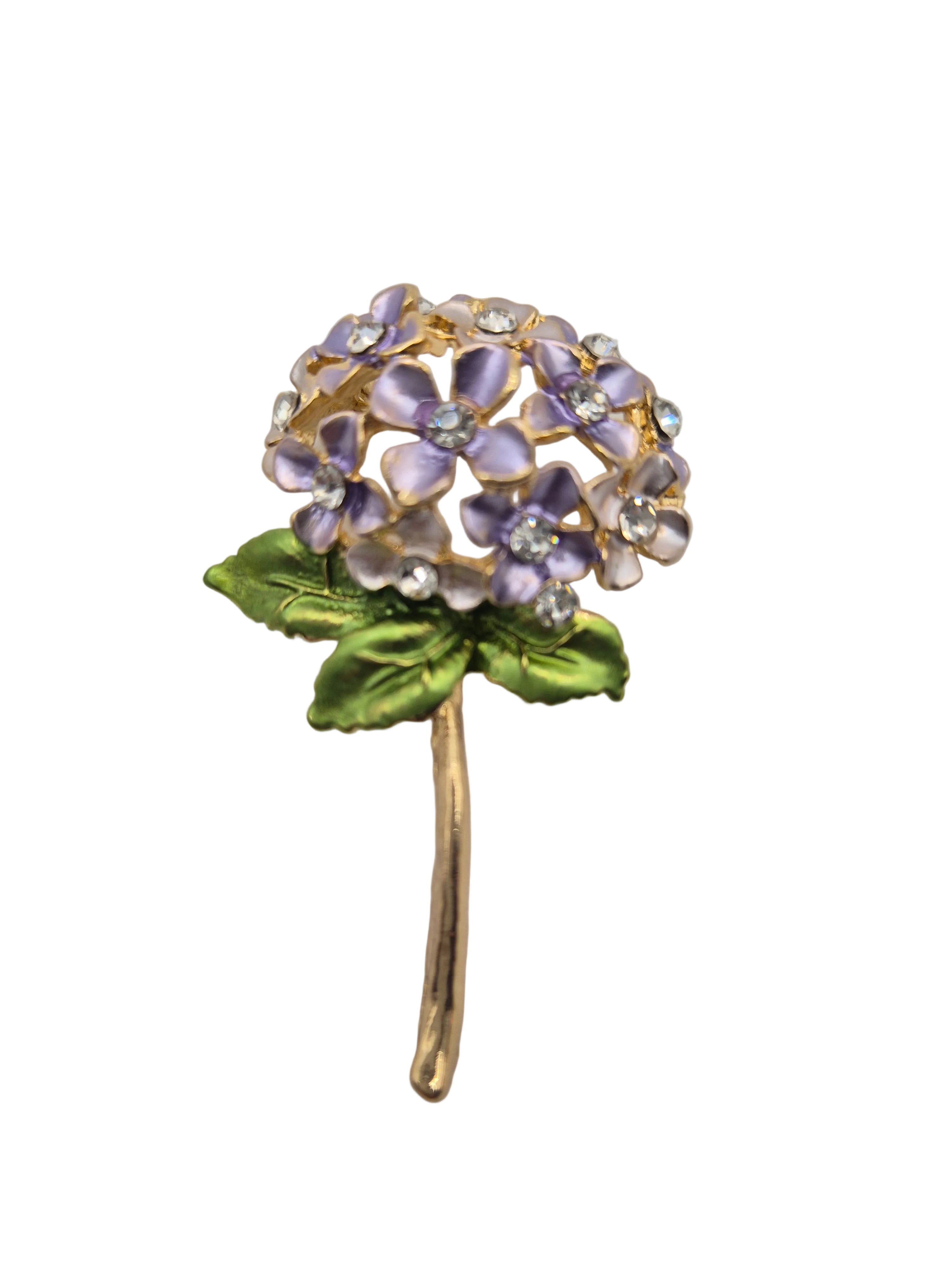 Floral brooch with purple flowers and green leaves on a light gray background