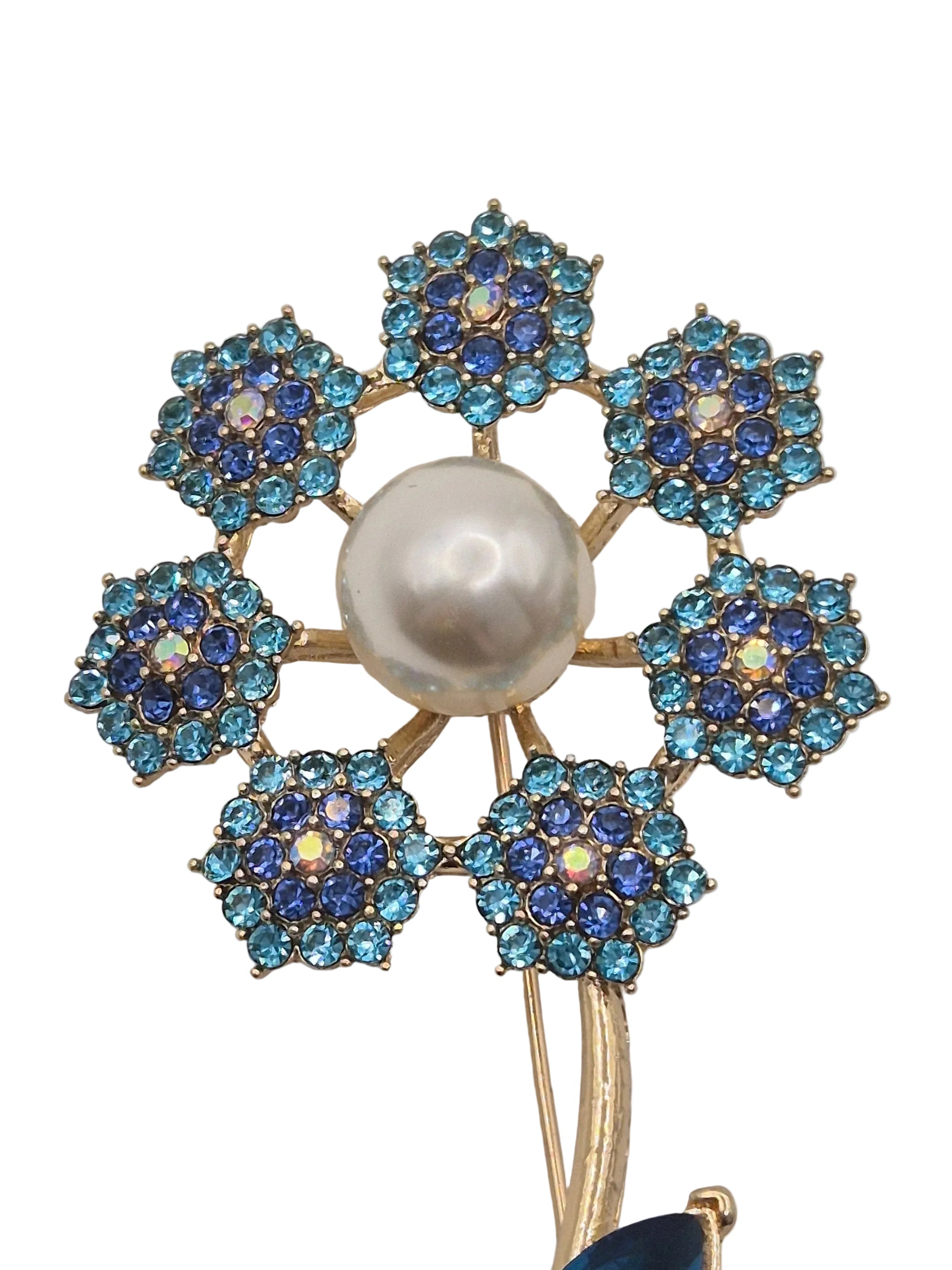 Jewelry brooch with blue gemstones and a pearl center on a white background