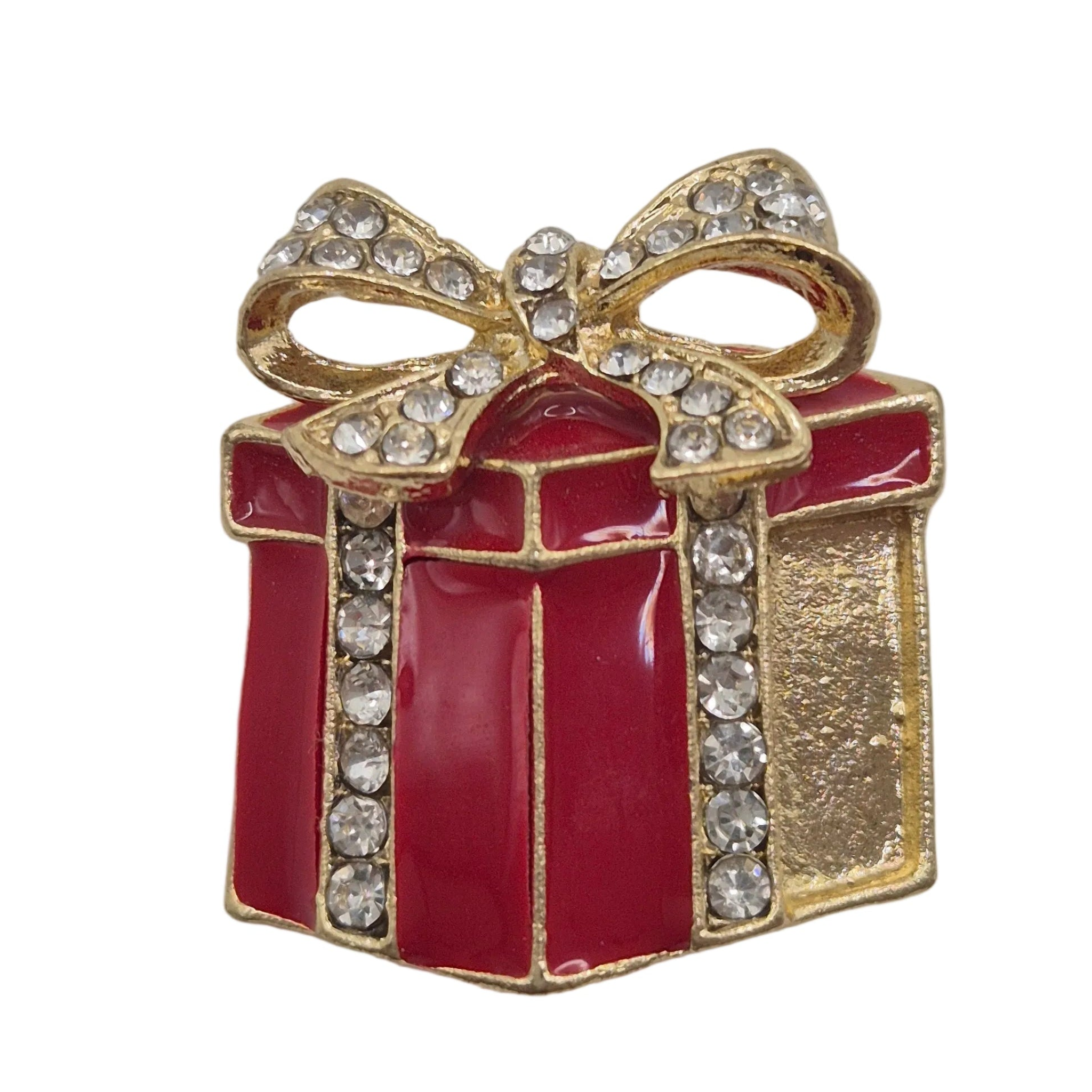 A gold gift box brooch with red enamel panels, a gold bow, and clear rhinestones, shown on a plain white background.