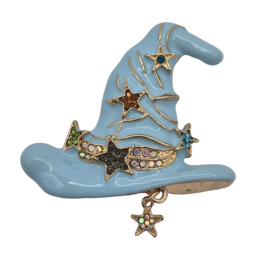 A light blue witch hat brooch with gold-tone metal trim, decorated with star-shaped charms and rhinestone accents in various colors, on a plain white background.