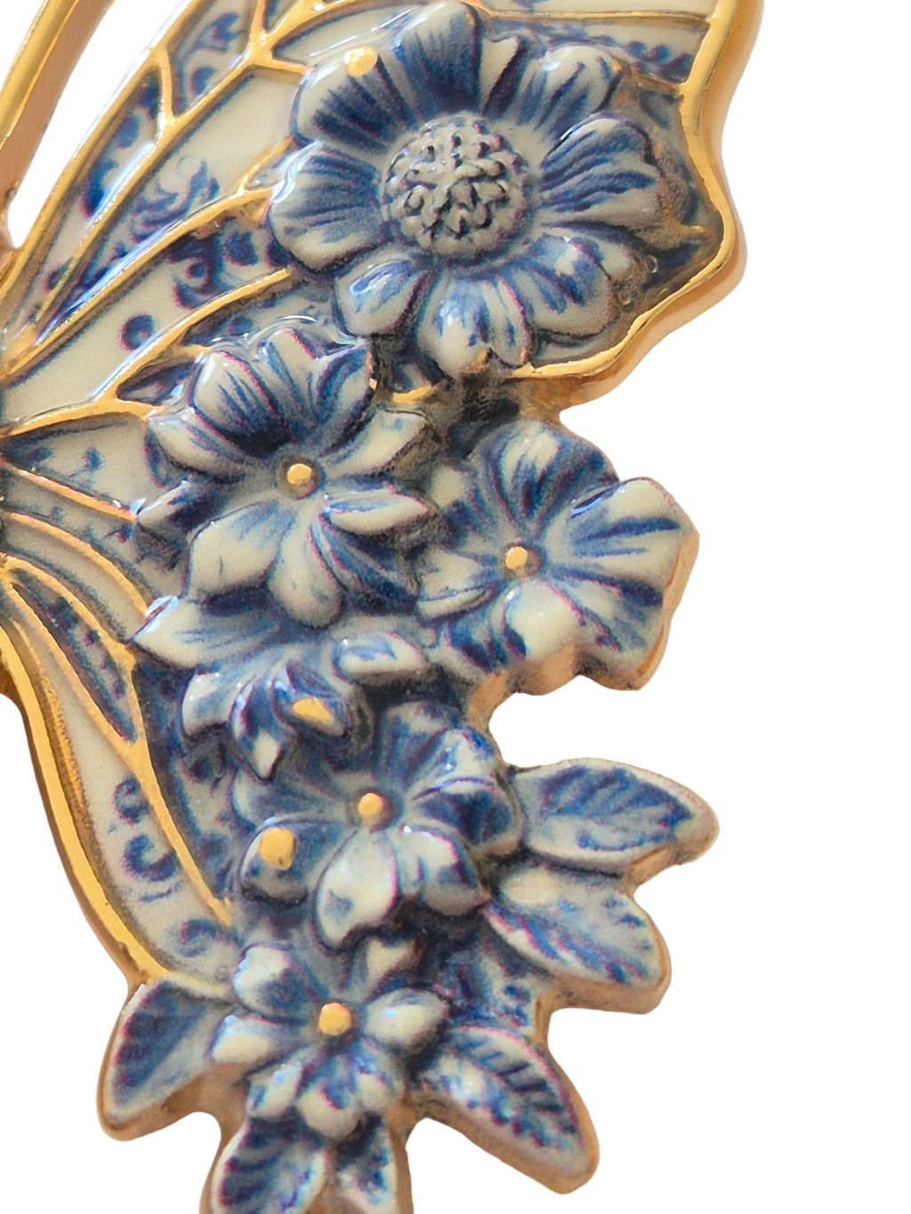 butterfly brooch with blue floral design on a white background