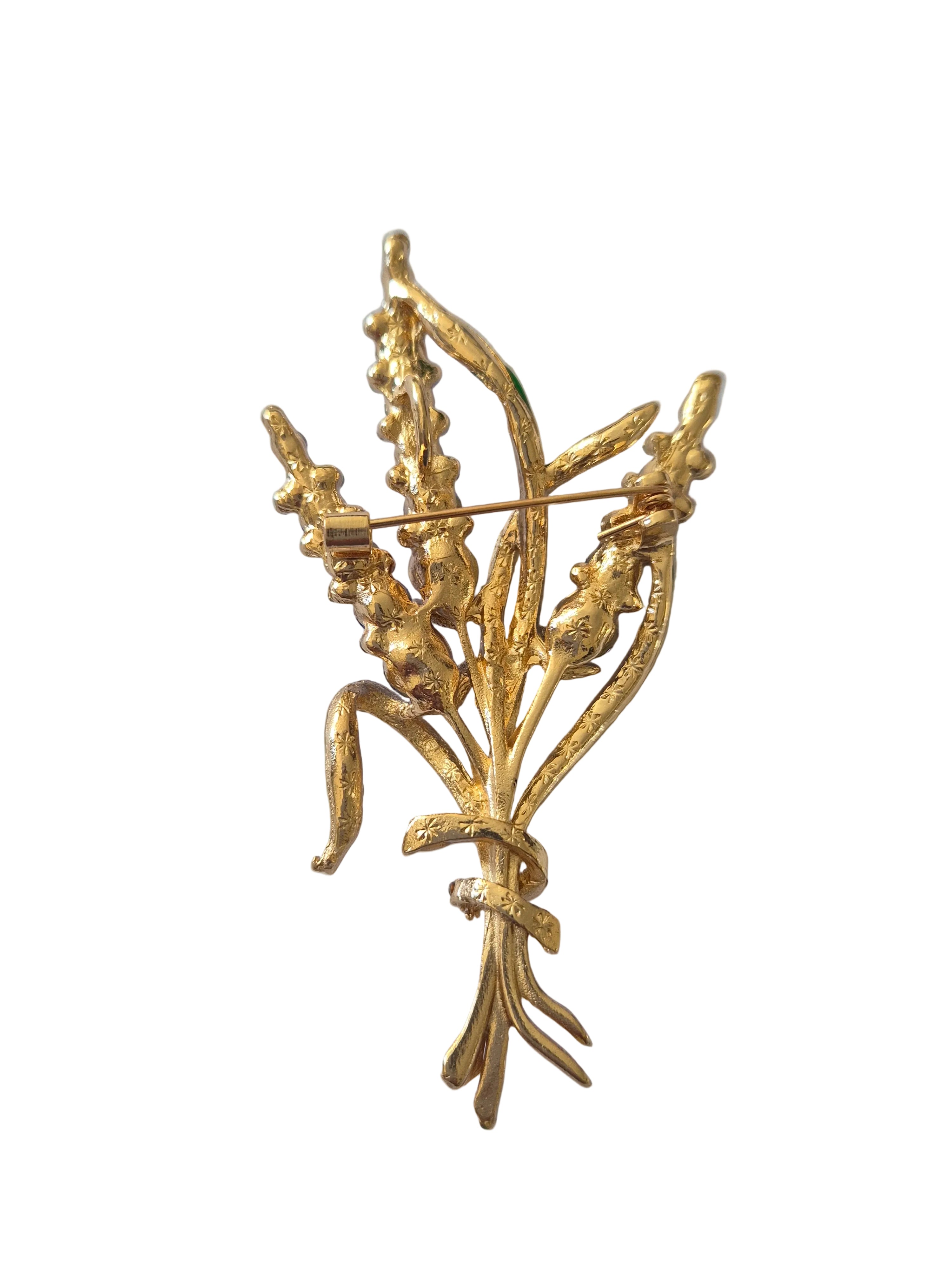 Gold brooch with floral design on a white background