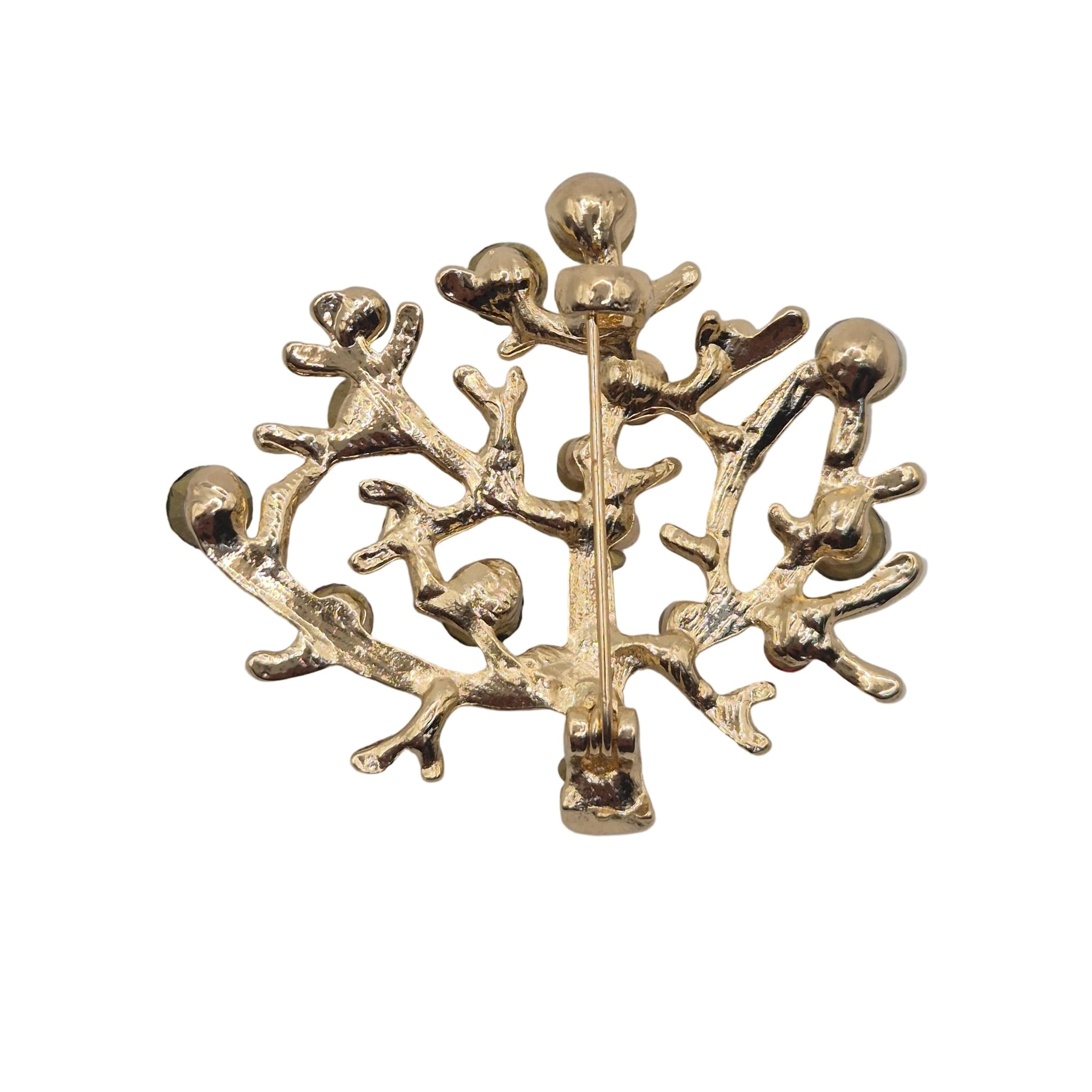 A gold-tone metal brooch shaped like a coral tree with branching limbs and small rounded leaf-like details, photographed on a plain white background.